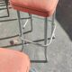 Pair of aluminum bar stools with orange and black seats