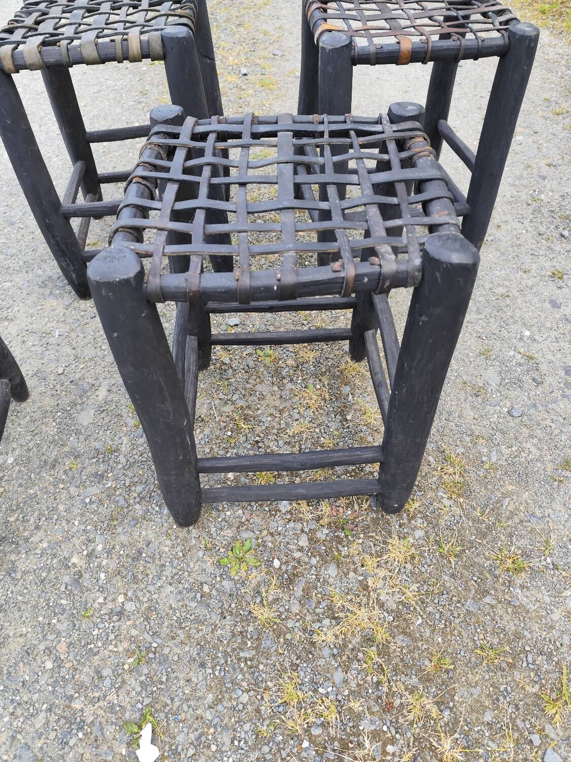 5 blackened wooden stools with woven leather seats by Nina Kaufmann