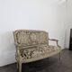 Cream lacquered Louis XVI style cabriolet salon with gold highlights.