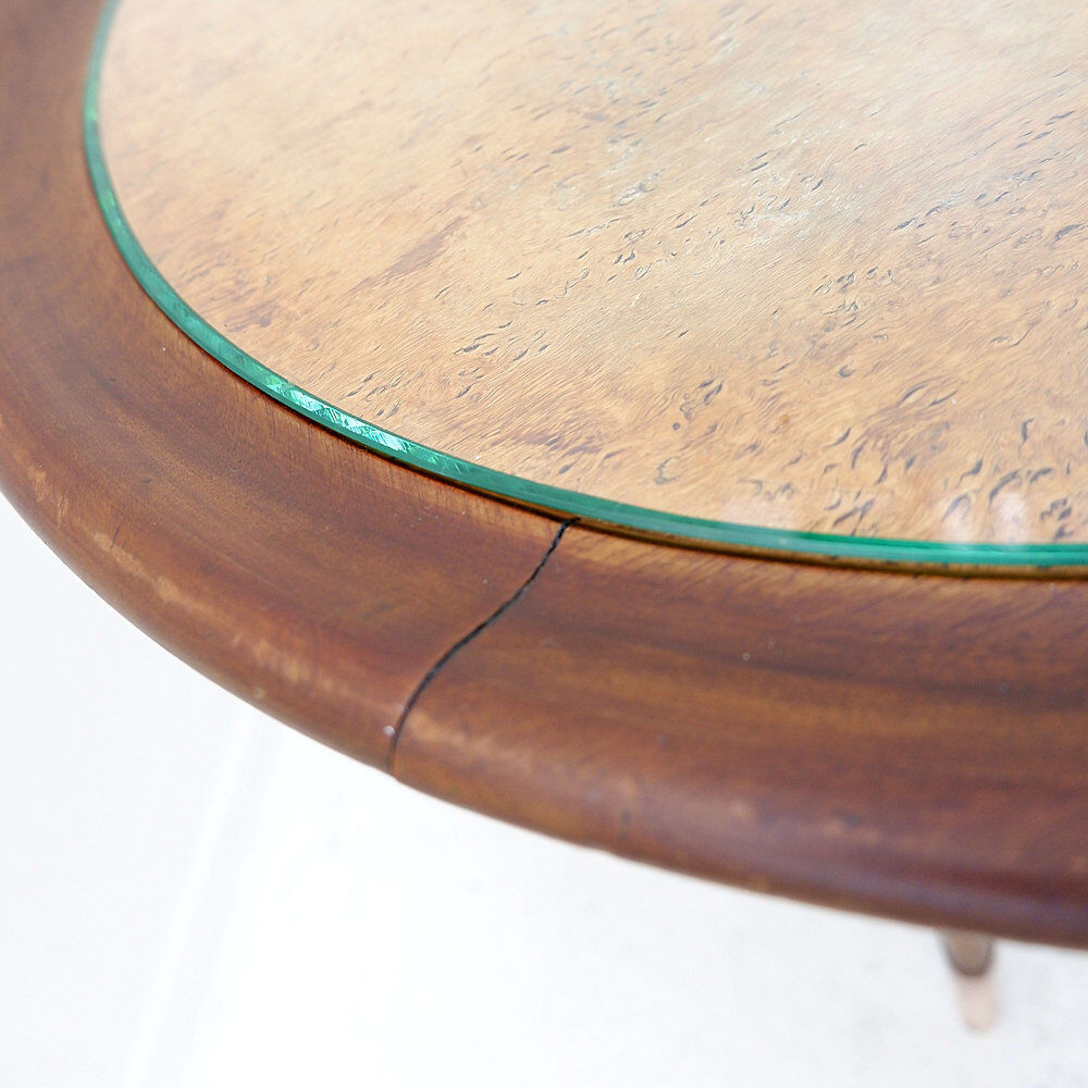 Round Art Deco side table in wood with curved legs and brass feet.