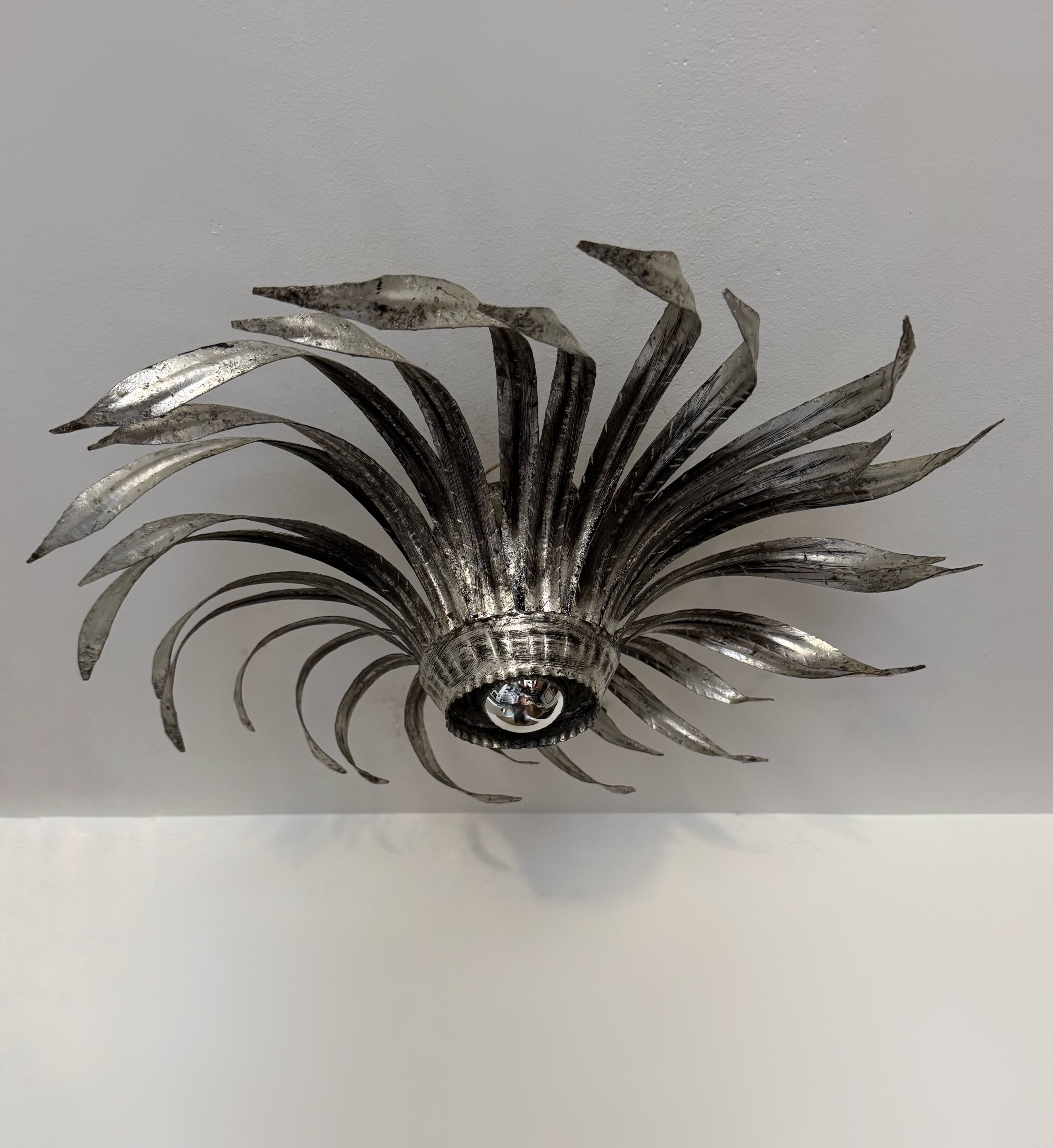 Silver wrought iron sunburst wall light from the 1960s.