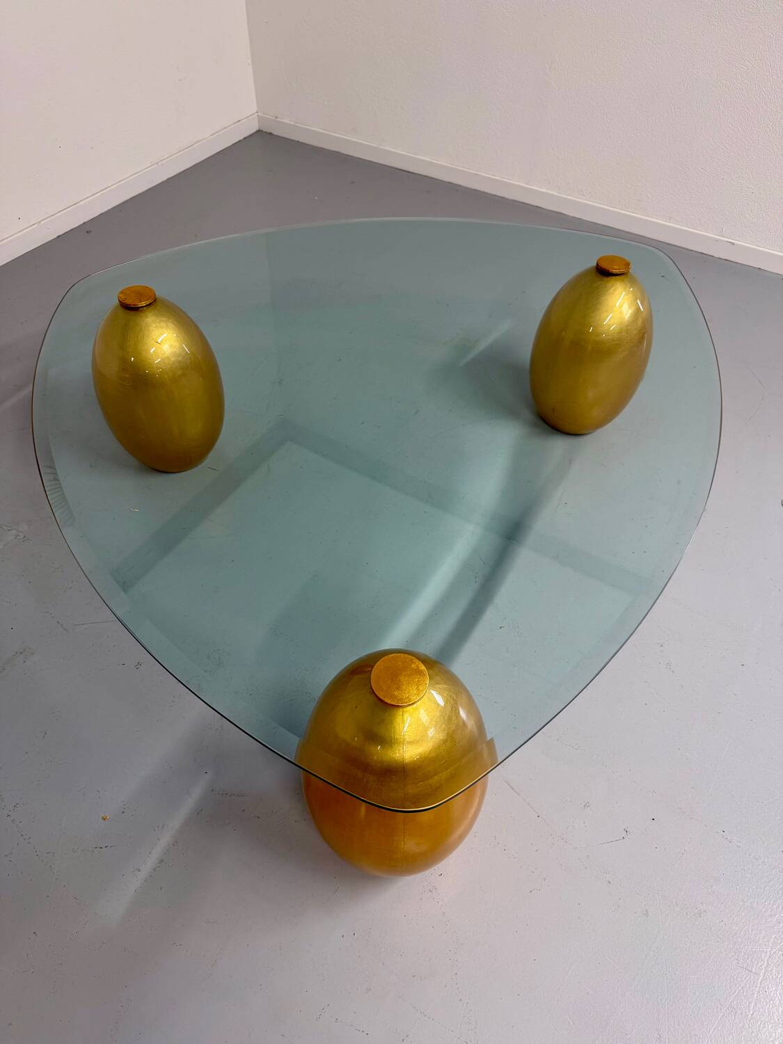 Vintage Italian design coffee table with a glass top and gold base, dating from the 1980s.