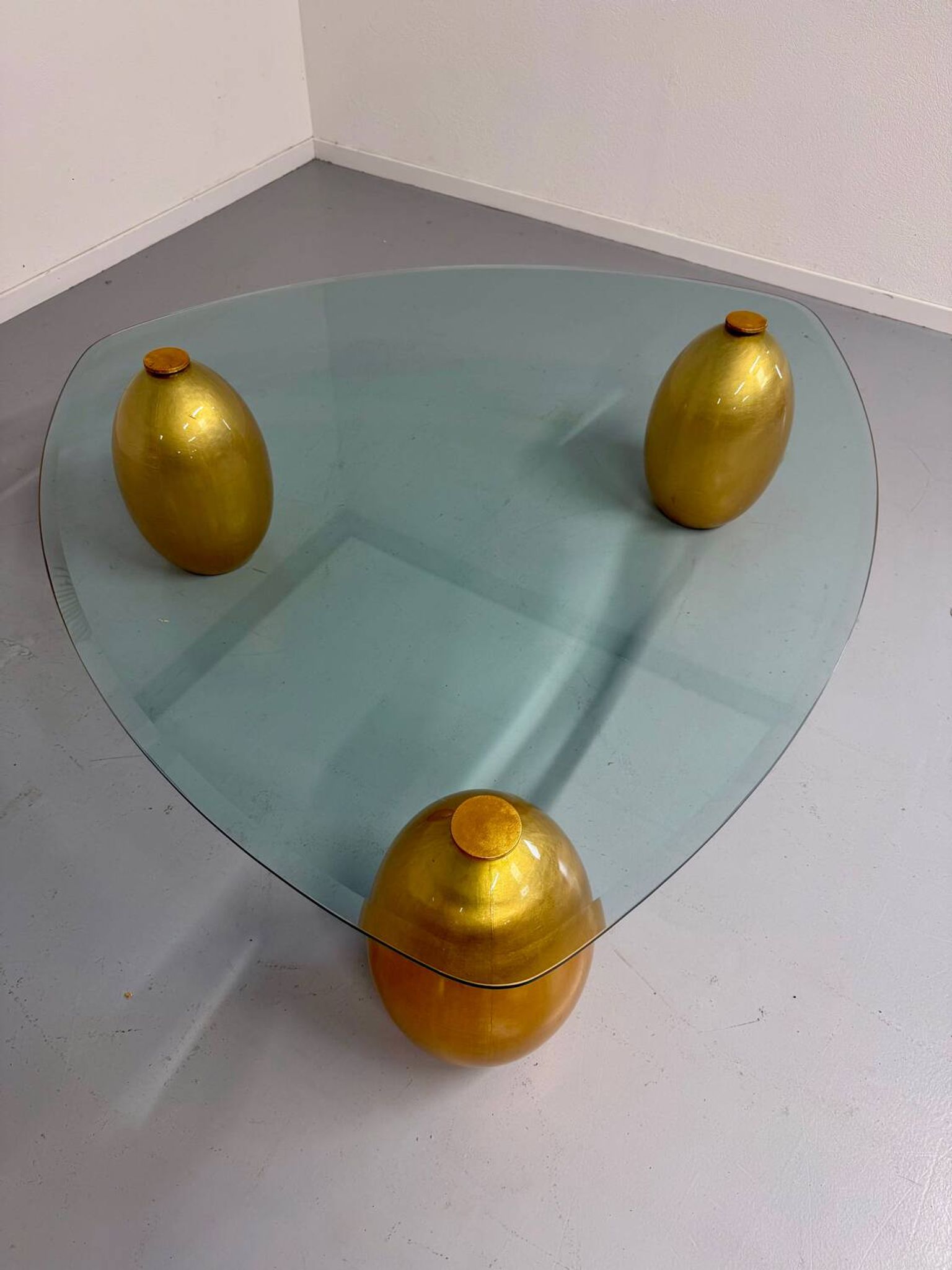 Vintage Italian design coffee table with a glass top and gold base, dating from the 1980s.