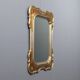 Antique mirror with a gilded frame and floral decorations, Italy, 20th century.