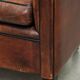 Sheepskin club armchair with deep warm colours and black piping