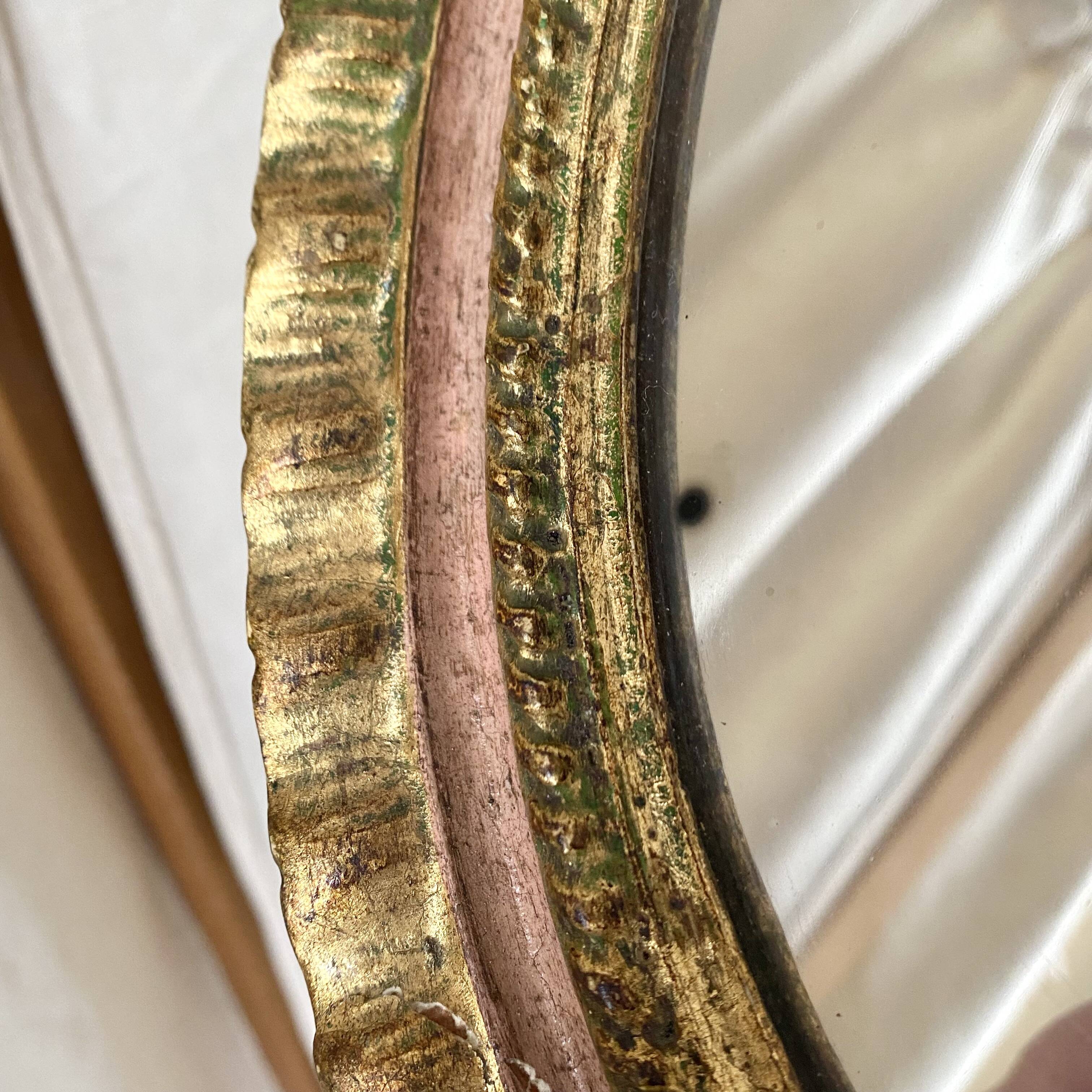 Oval Florentine mirror in powder pink and gold wood, 1960s.