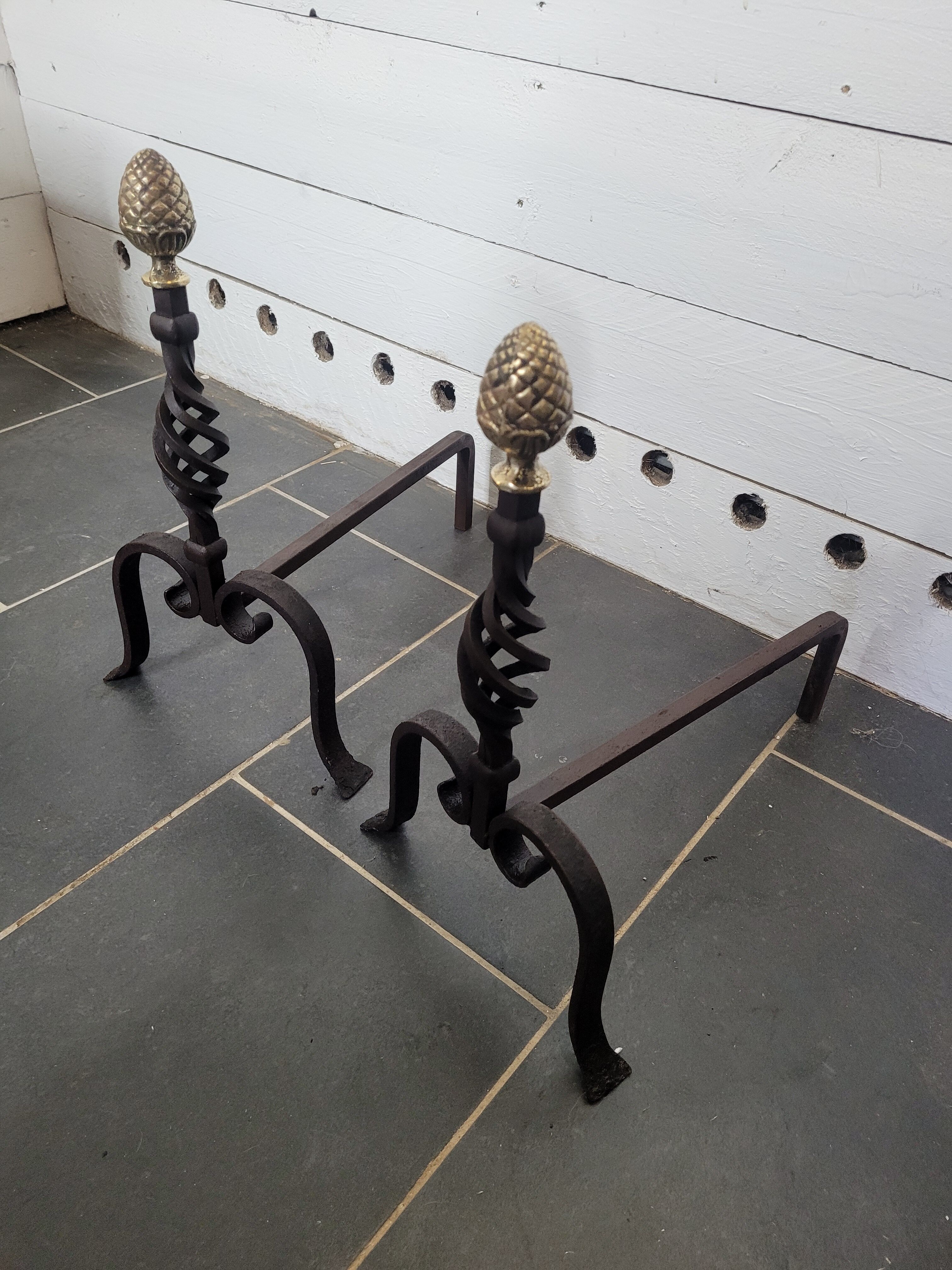 Old pair of wrought iron pegs with brass pine cone