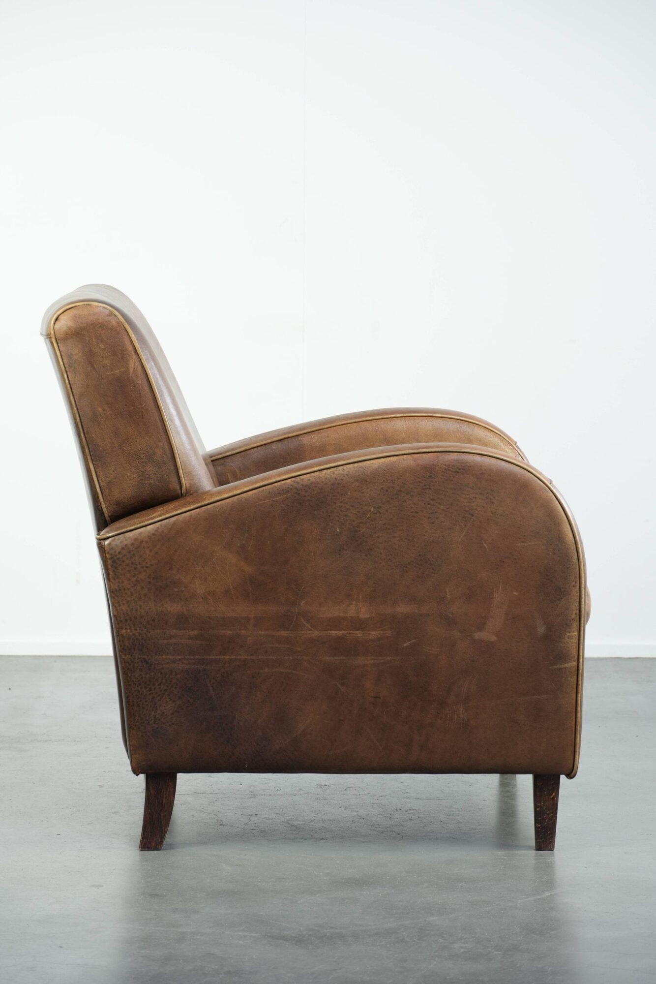 Set of a sheepskin armchair and ottoman finished with matching piping