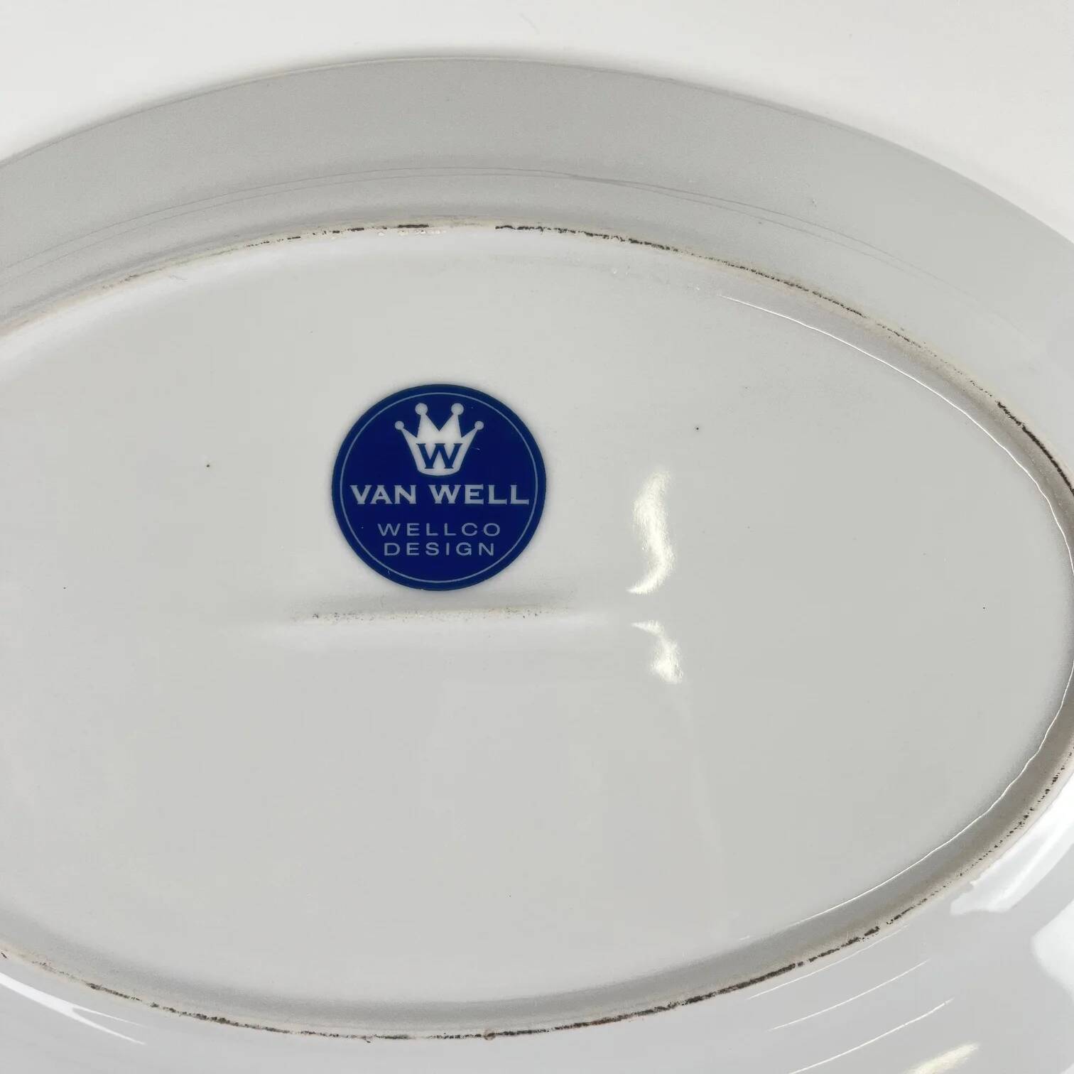 Oval porcelain plate by Van Well, multicoloured geometric border, 1980.