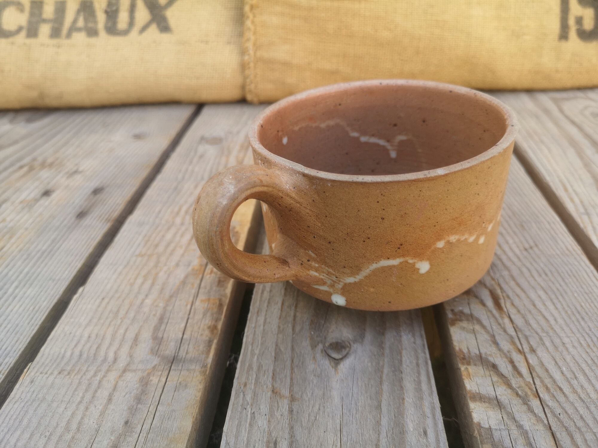 Brown sandstone cup with white spots