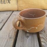 Brown sandstone cup with white spots