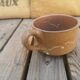 Brown sandstone cup with white spots