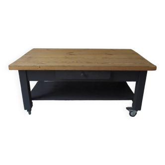 Coffee table on casters, 1 drawer, 1 shelf. Slate gray base and headband, wooden top.