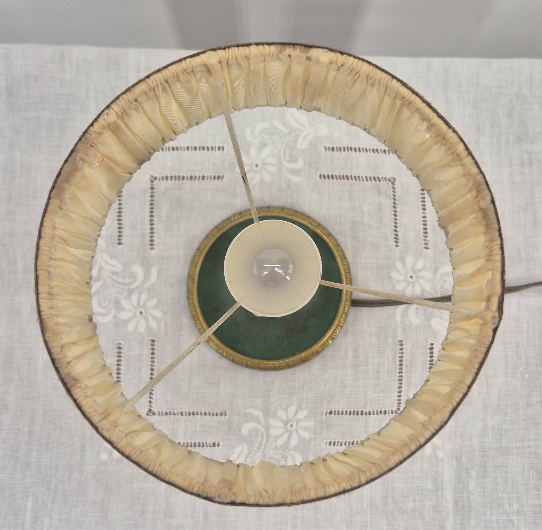 Brass table lamp with green patina and empire-style fabric shade.