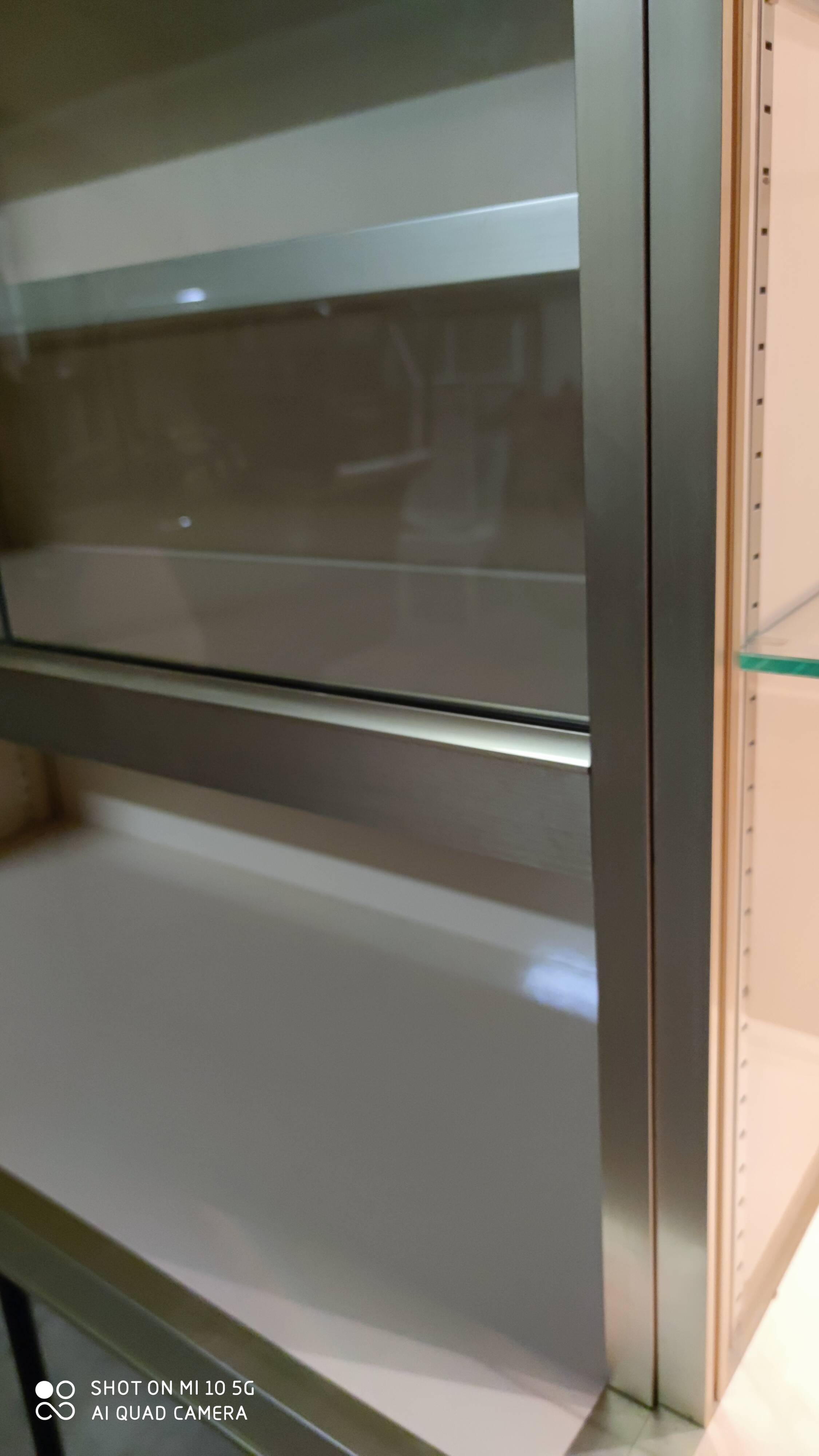 Ivory-colored and matte gold anodized aluminum display bookcase