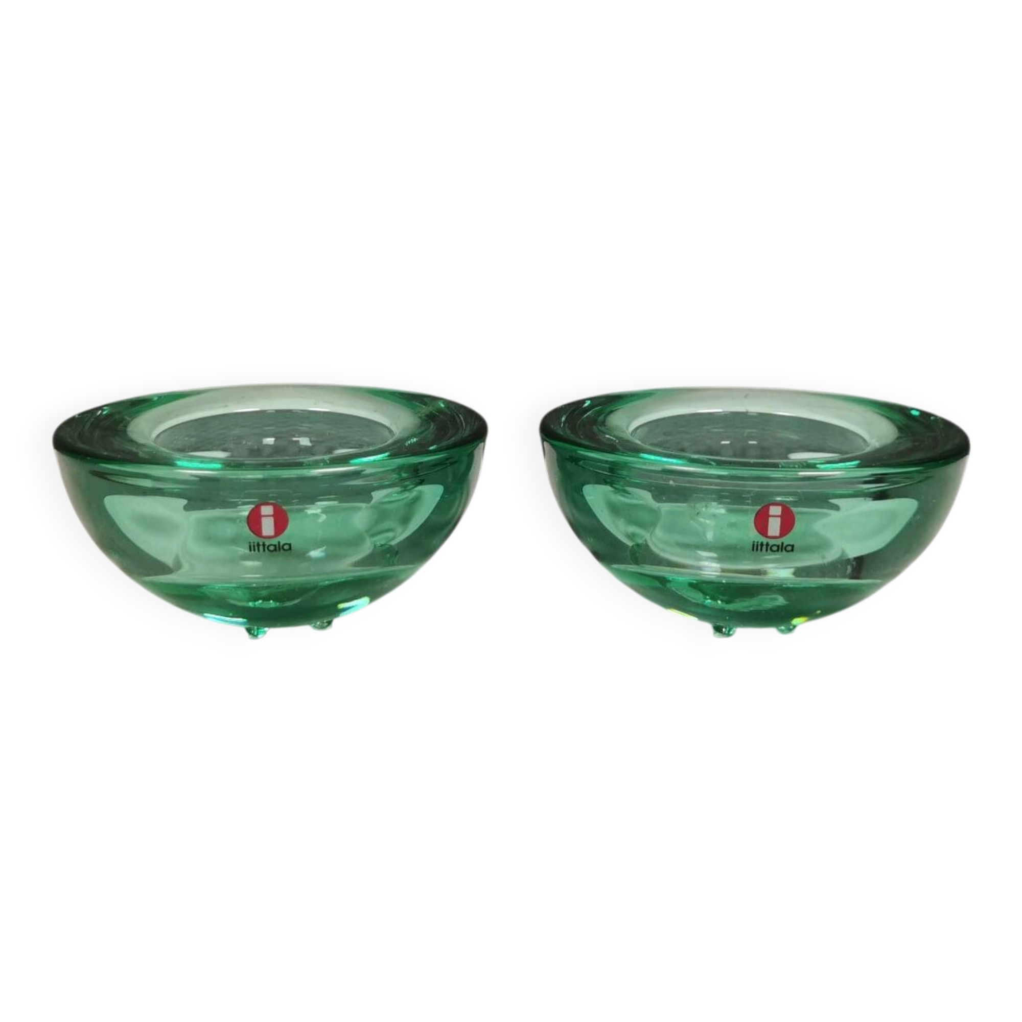 A set of iitalla candle holders in green transparent glass.