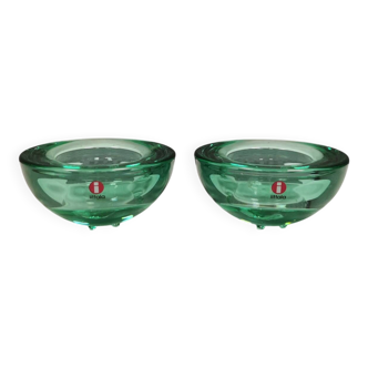 A set of iitalla candle holders in green transparent glass.