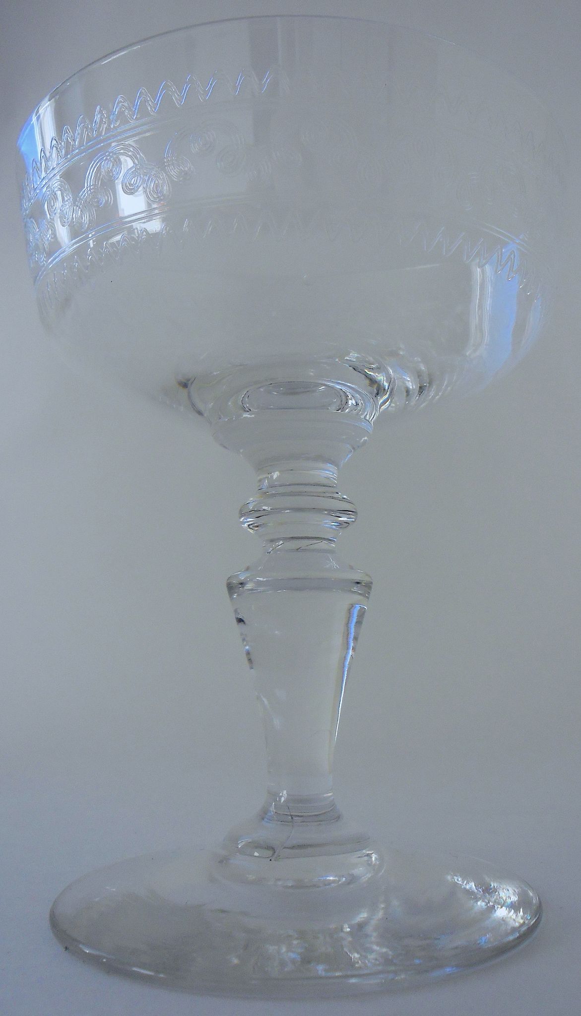Suite of six champagne glasses on foot in engraved colorless crystal