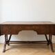 Antique wooden desk with a faux leather top and extensions.