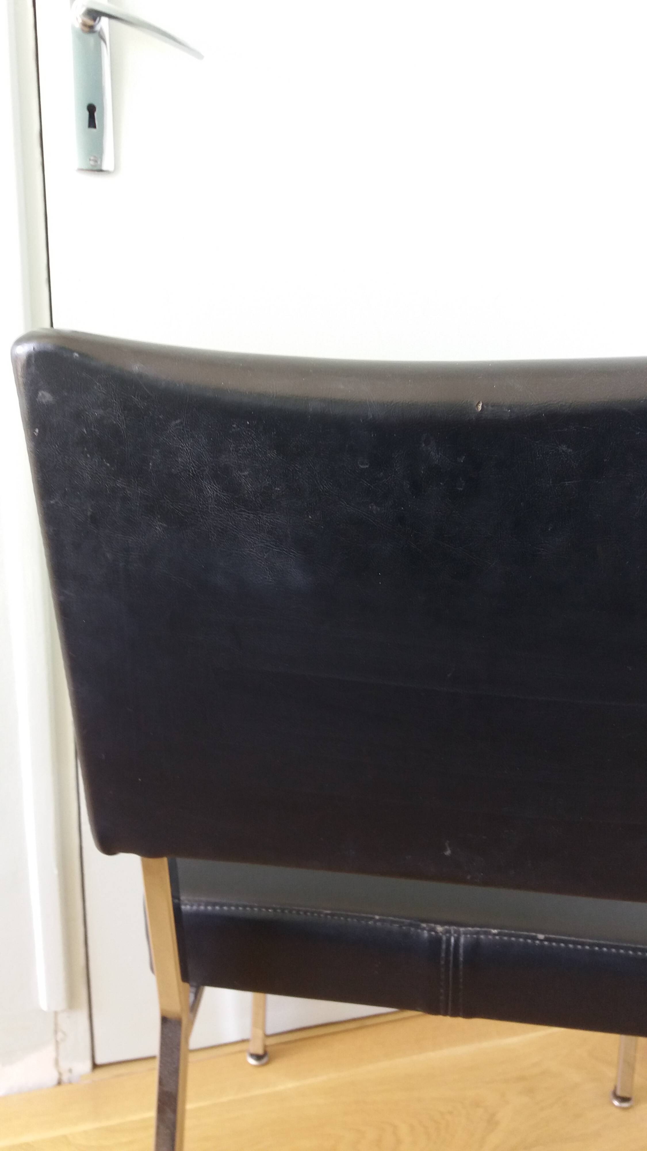 Chrome metal chairs and black faux leather upholstery in retro modernist style.