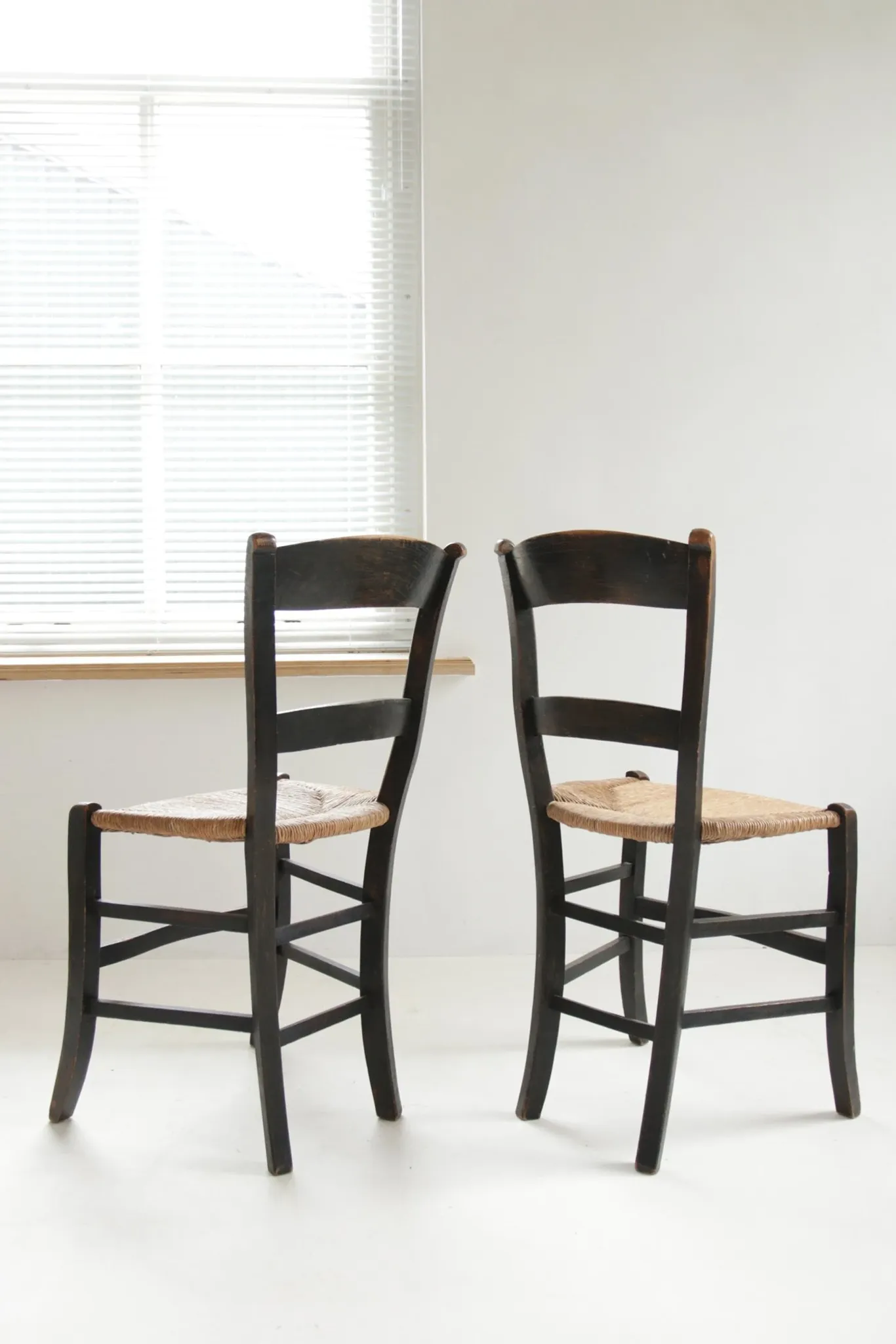 Pair of antique Northern French black-stained chairs with rush seats