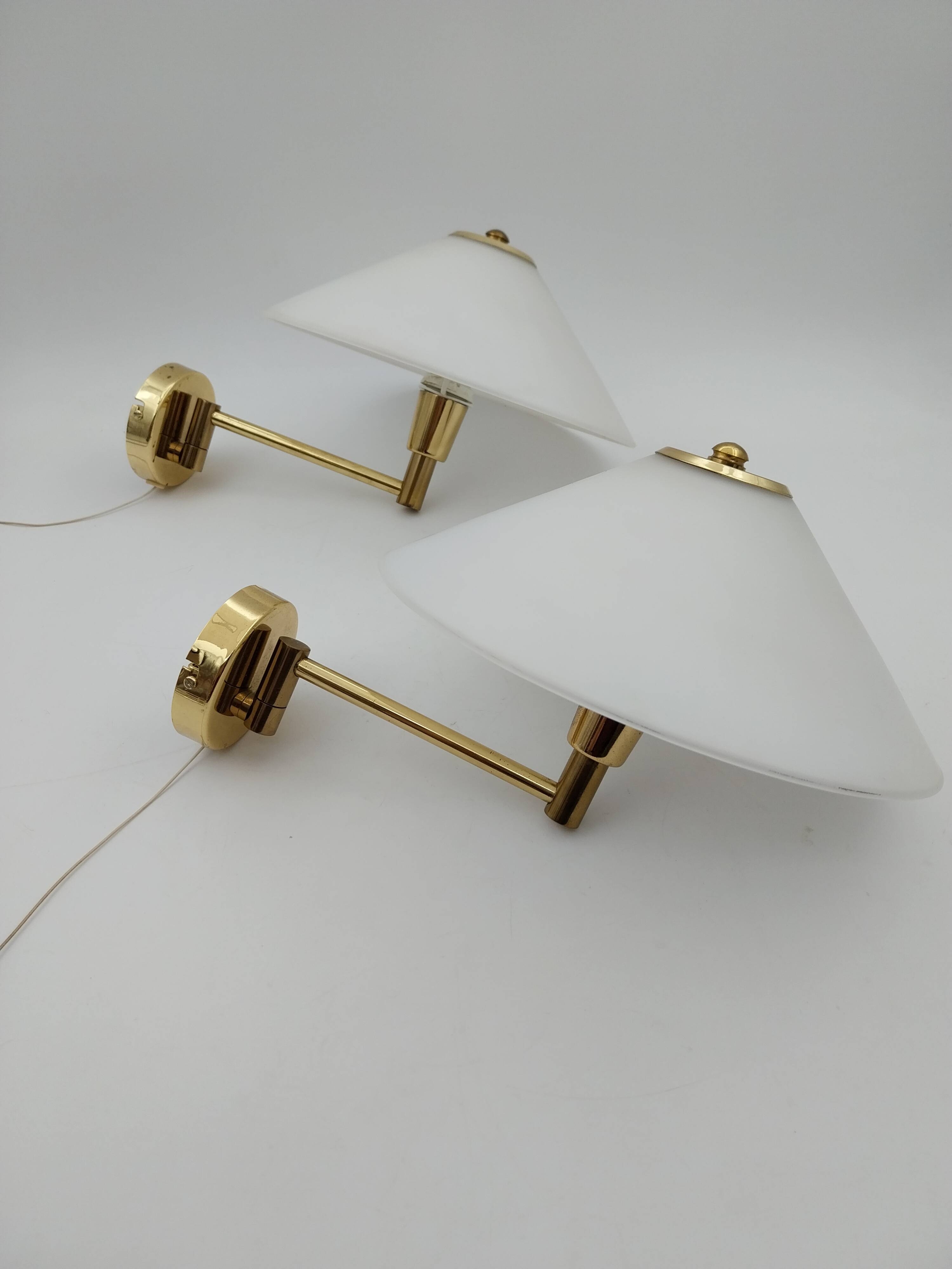 Pair of articulated arm wall lights in brass with opaline globe