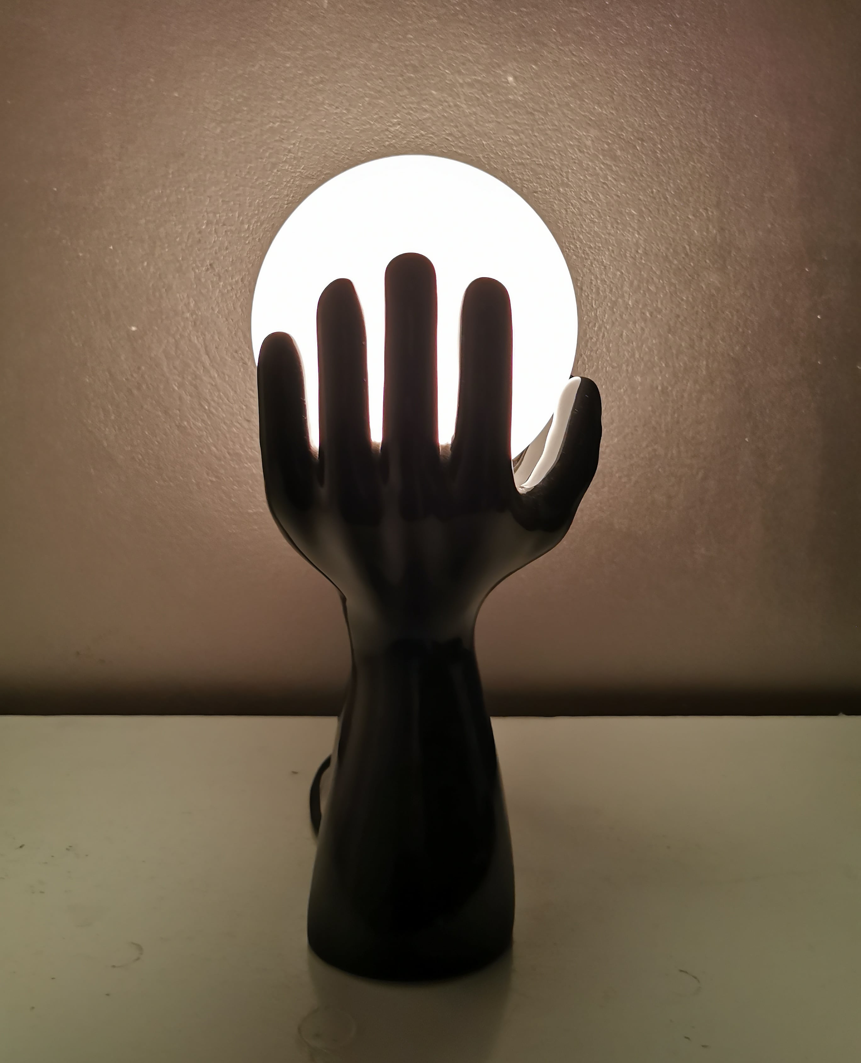 Italian design ceramic table lamp, two hands and glass shade.