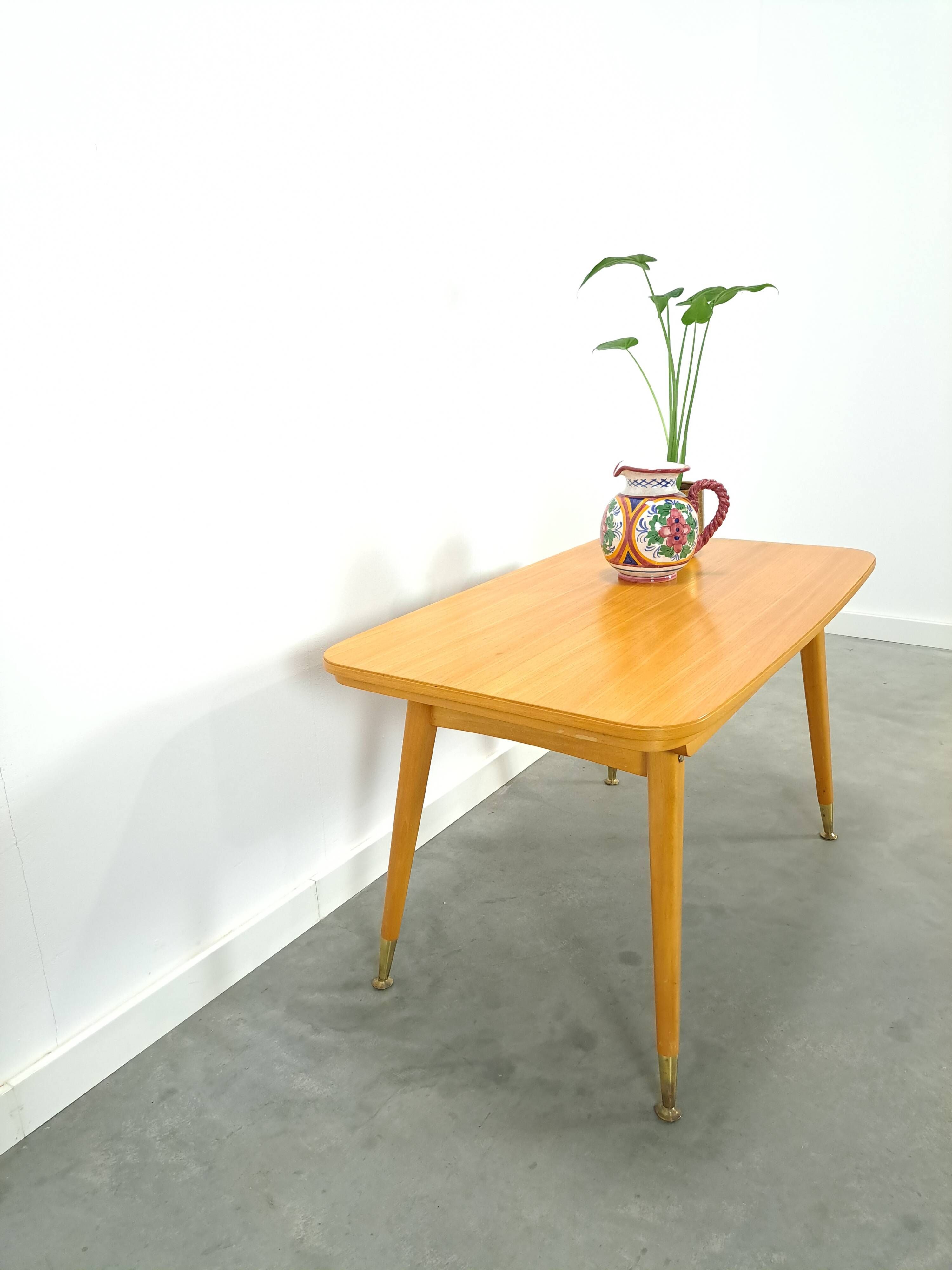 Vintage veneer table with pretty angular legs and brass at the base of the legs.