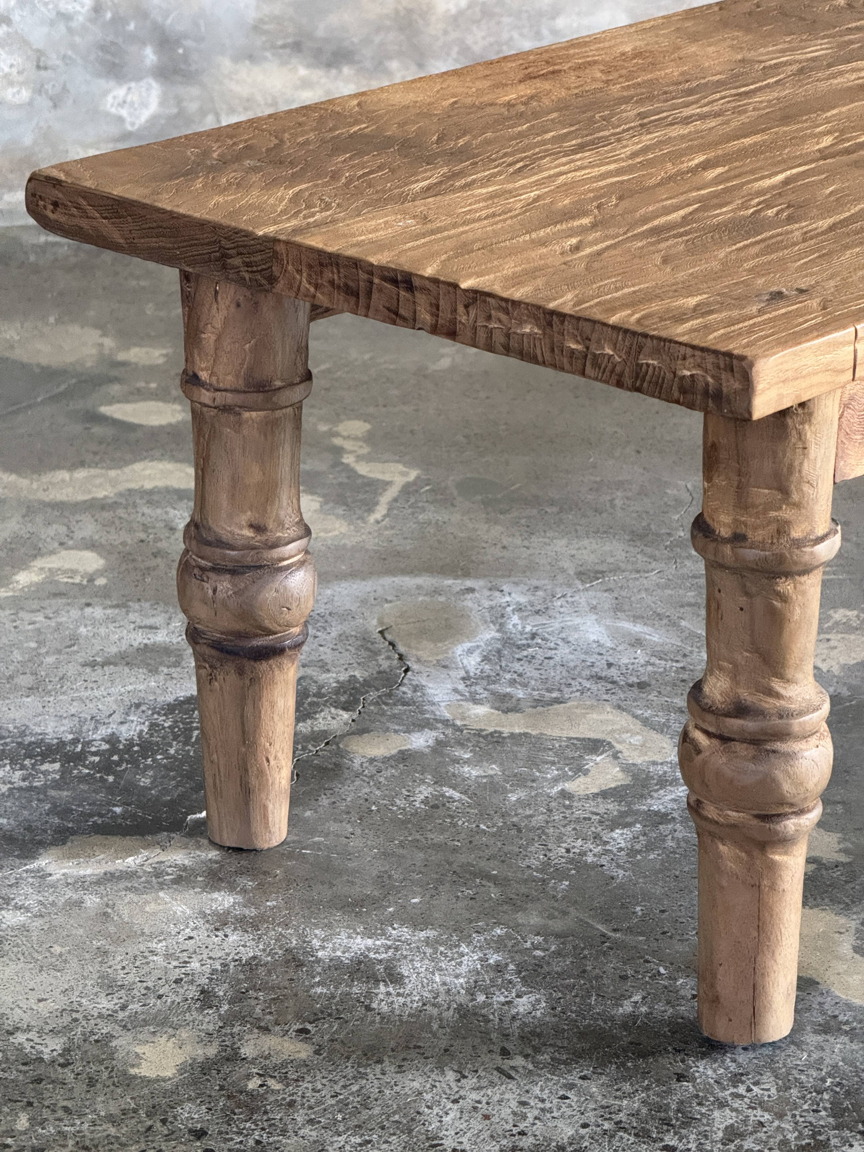 Brown Indonesian teak coffee table, with a border and cylindrical legs H40 L103.