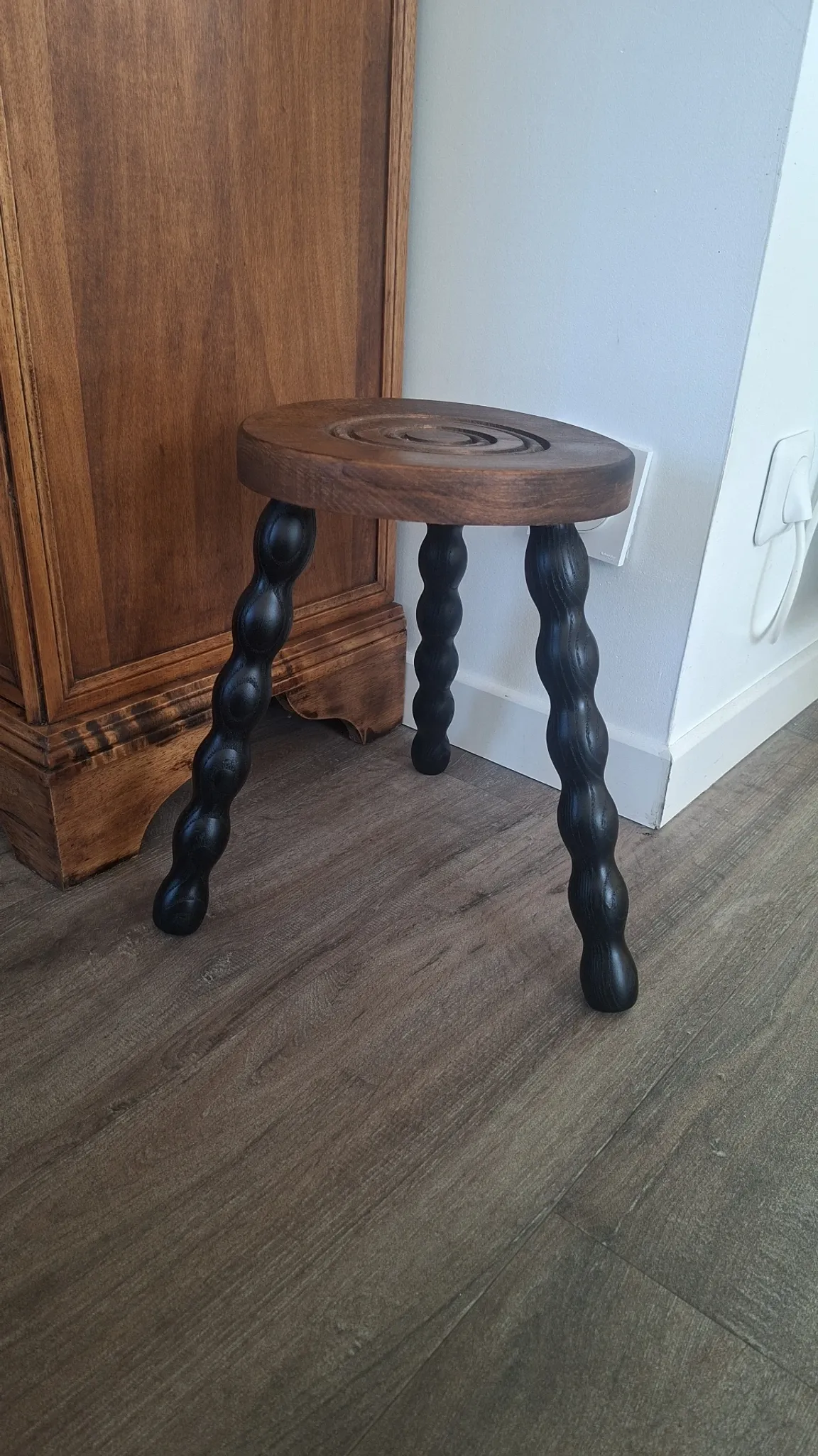 Brown and black wooden tripod stool