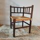 Old wooden turned spindle fireside chair with a straw seat.