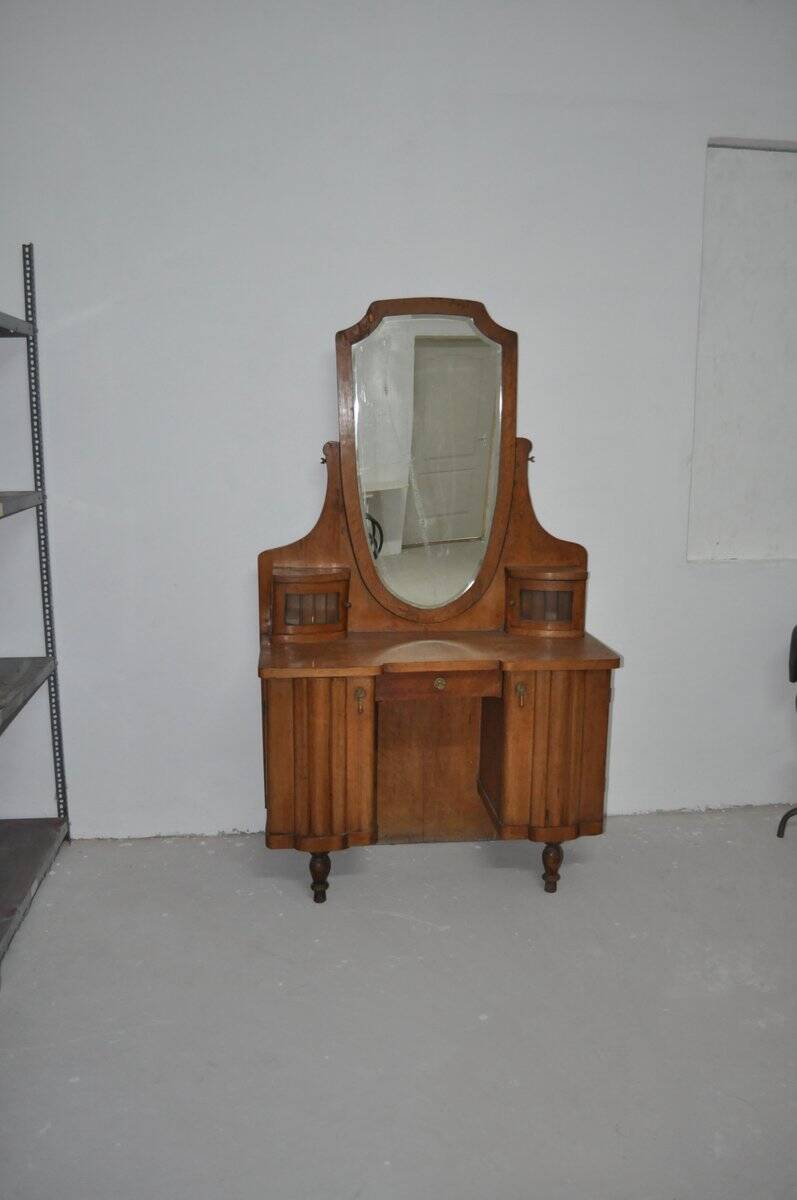Large vintage brown wooden dressing table with an oval mirror and built-in storage.