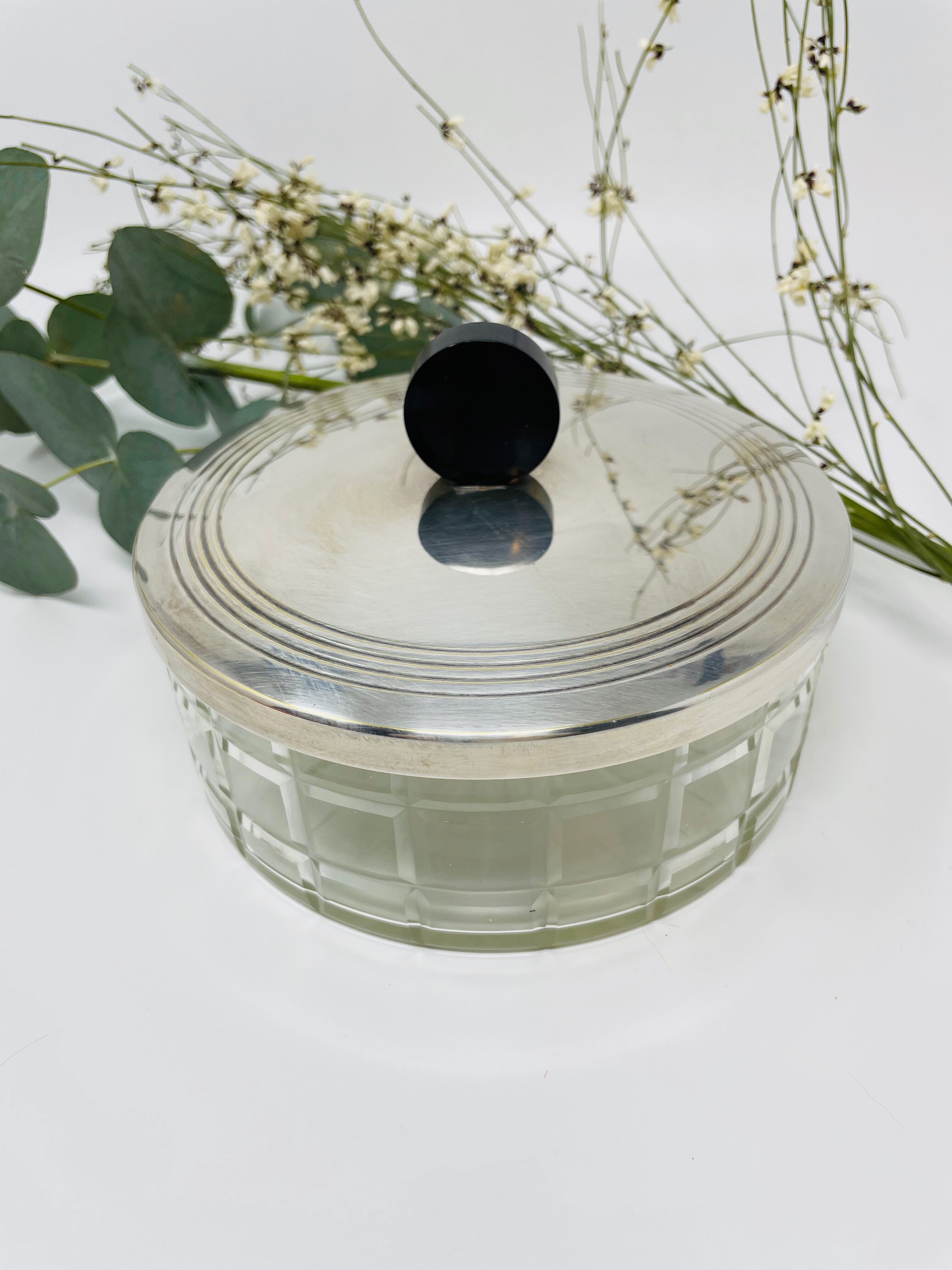 Vintage box made of chiseled glass and covered metal, taken in black Bakelite