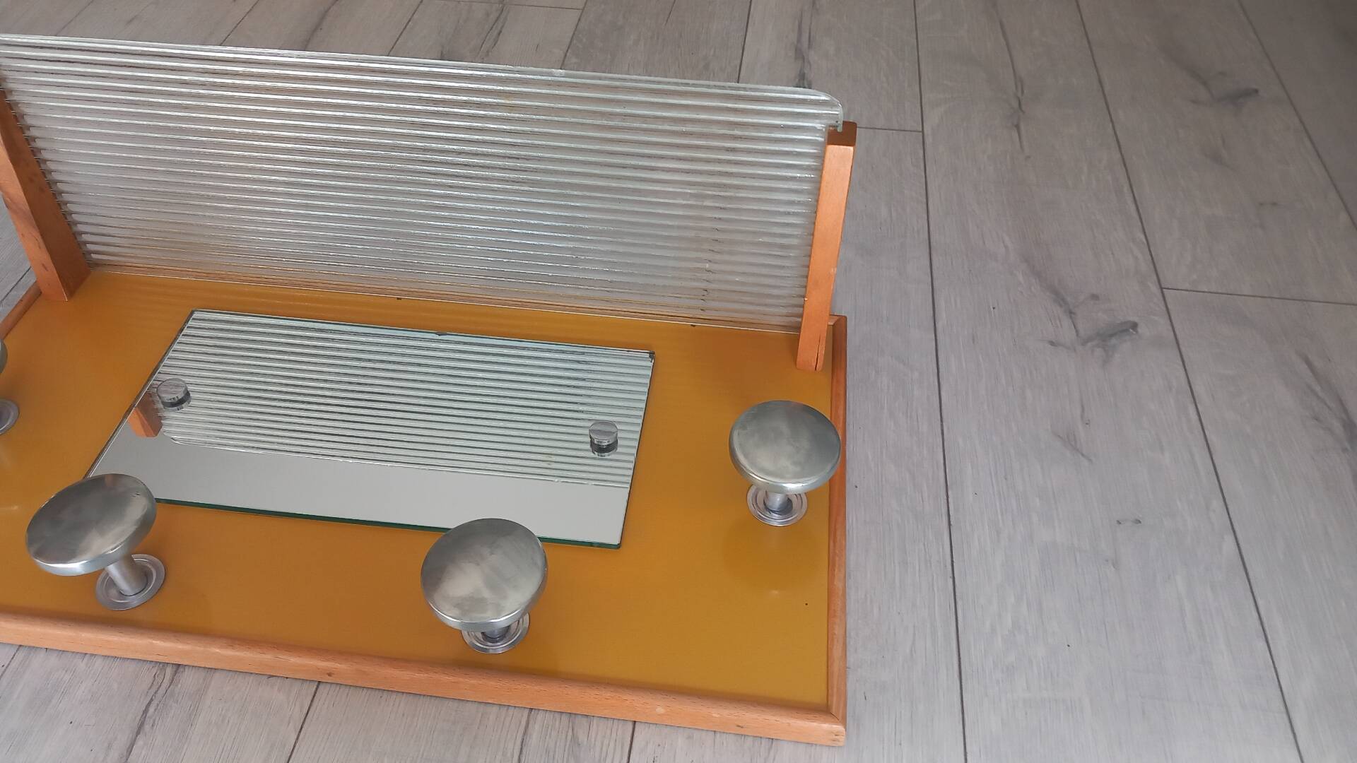 1950s coat rack with mirror, metal hooks, and glass shelf.