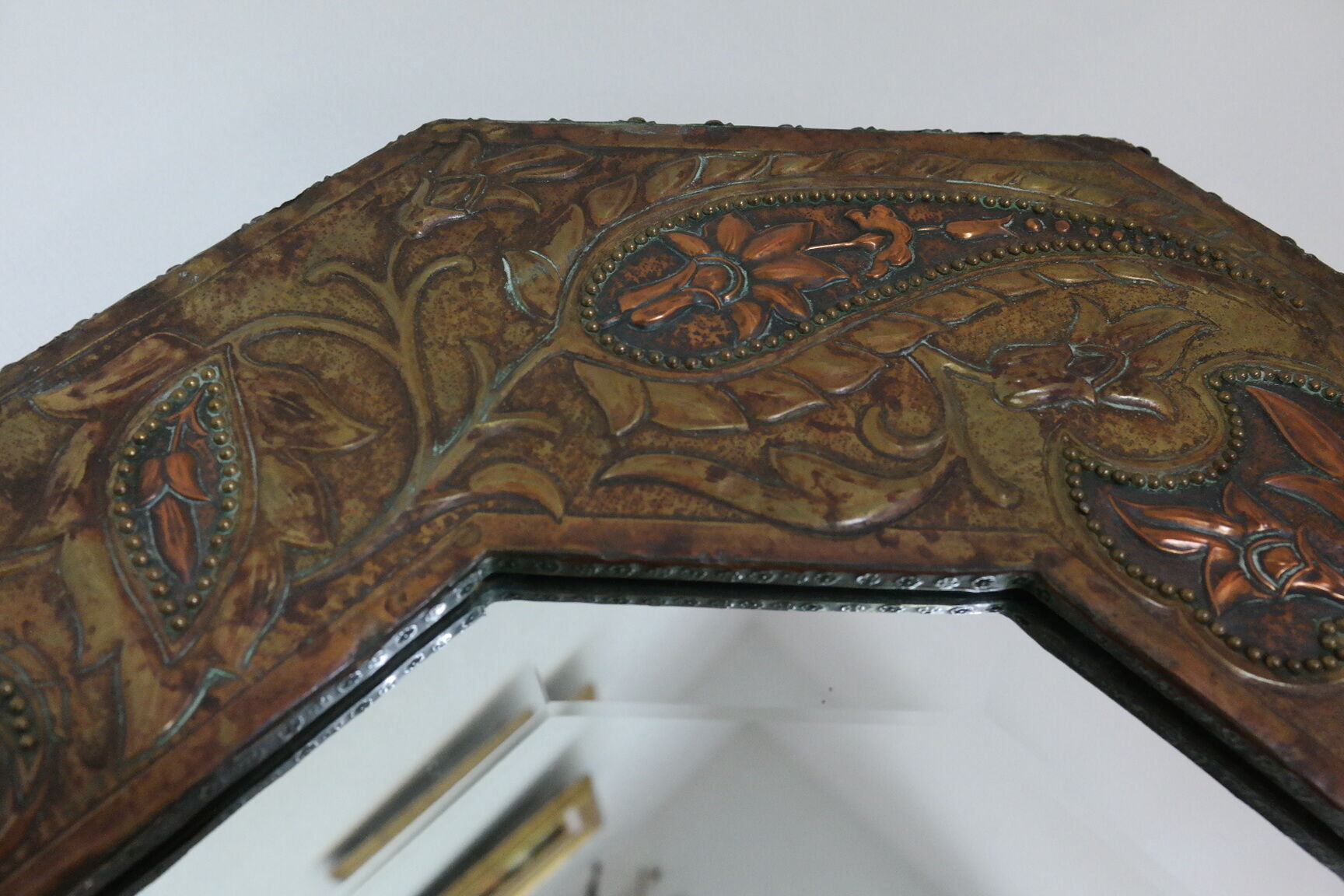 Antique bevelled artisanal mirror in repoussé copper - 54x45cm