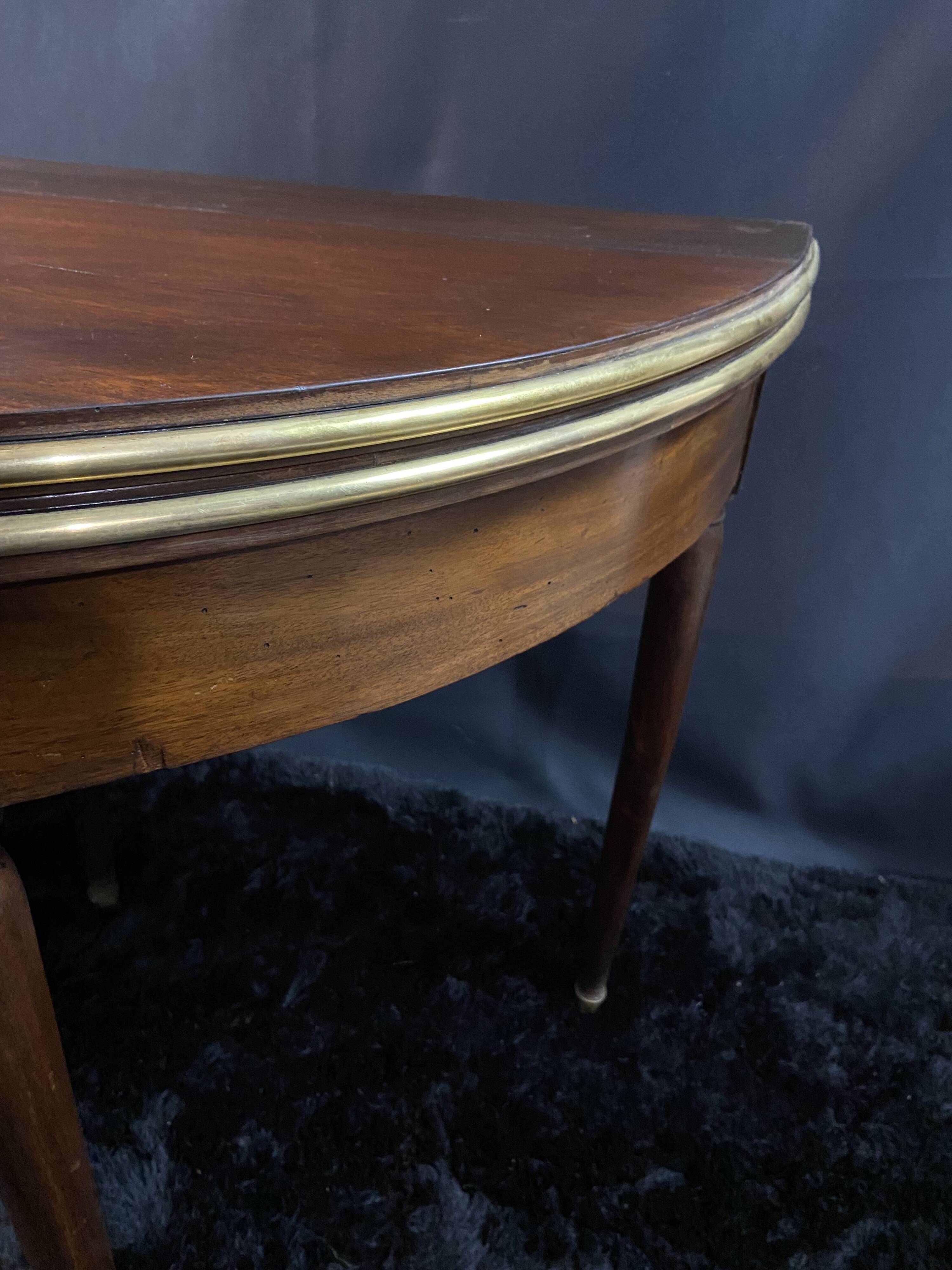 A Louis XVI period mahogany half-moon table forming a console/games table