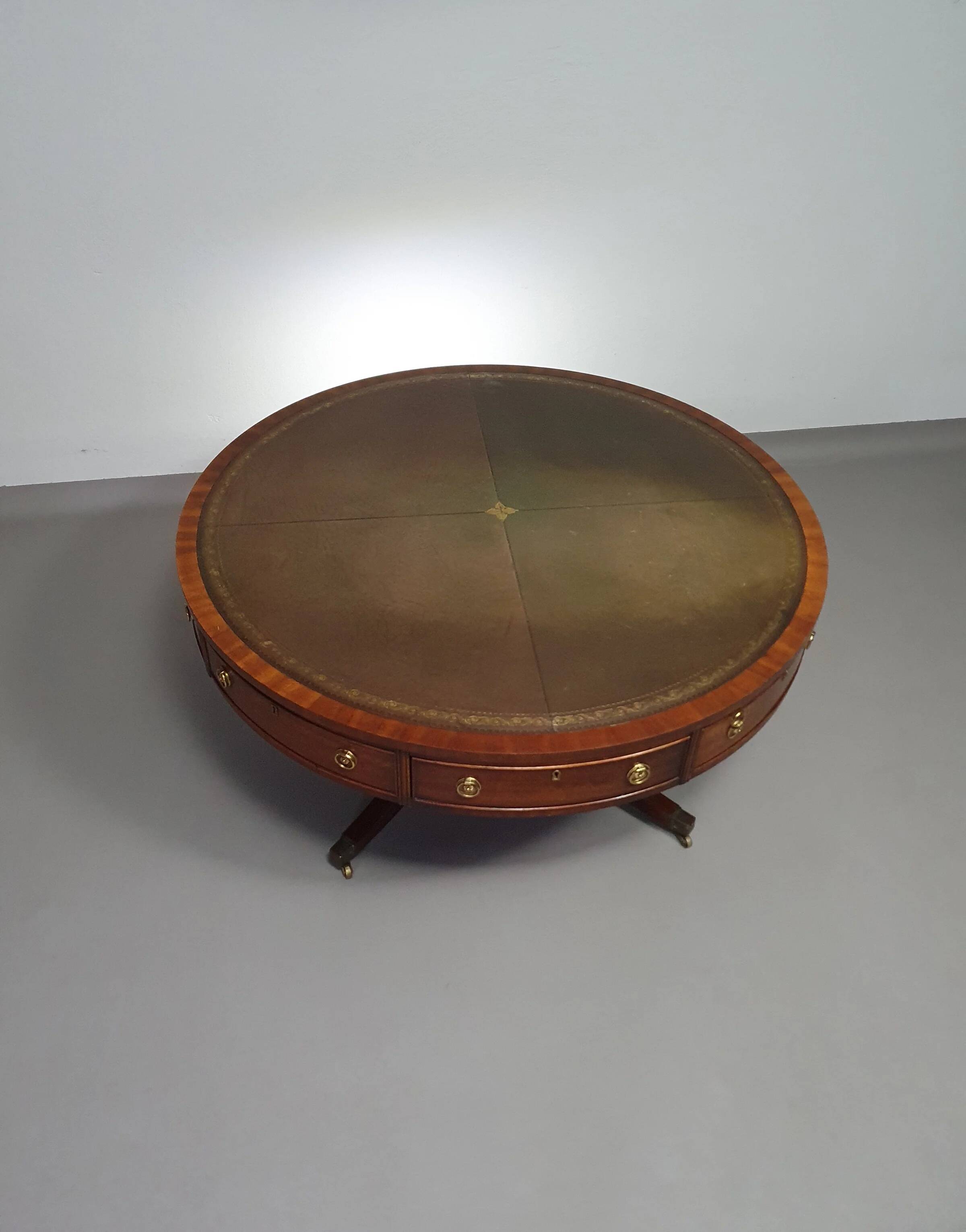 Table basse / table tambour victorienne « Heldense » en acajou avec plateau en cuir sur roulettes en laiton. Années 1980