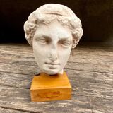 Tête en plâtre d’une déesse antique sur son socle en bois