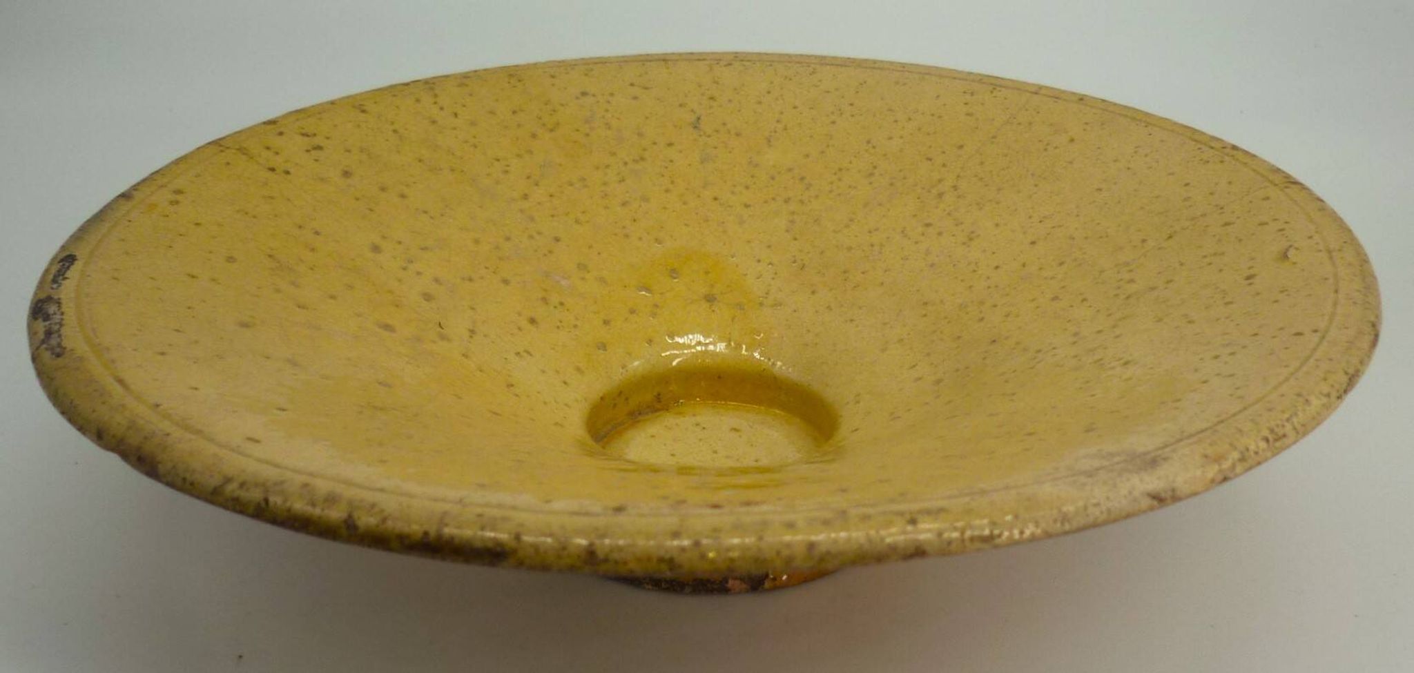 Old omelette turner, glazed yellow terracotta, south of France.