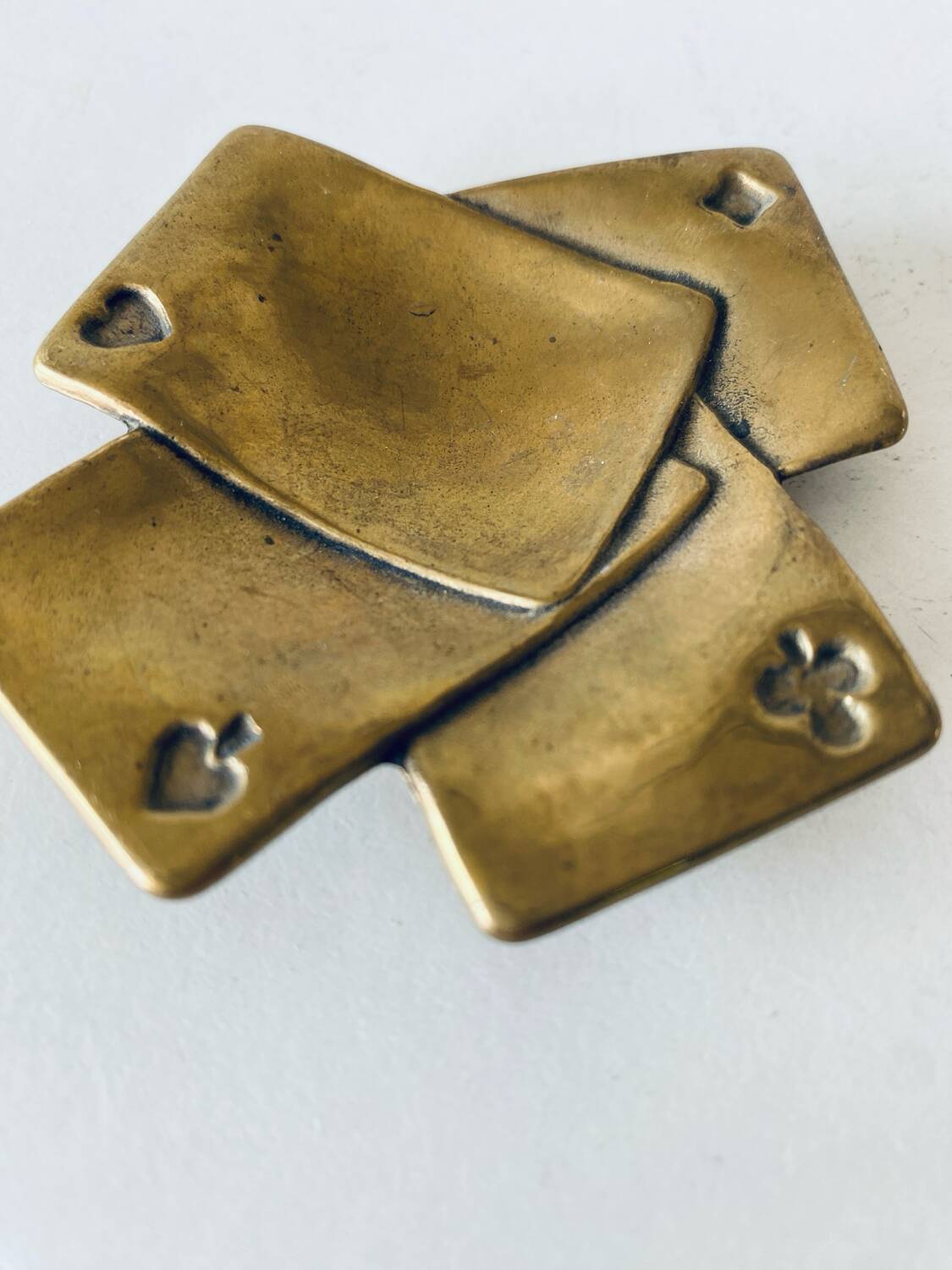 Empty pocket square of aces in brass