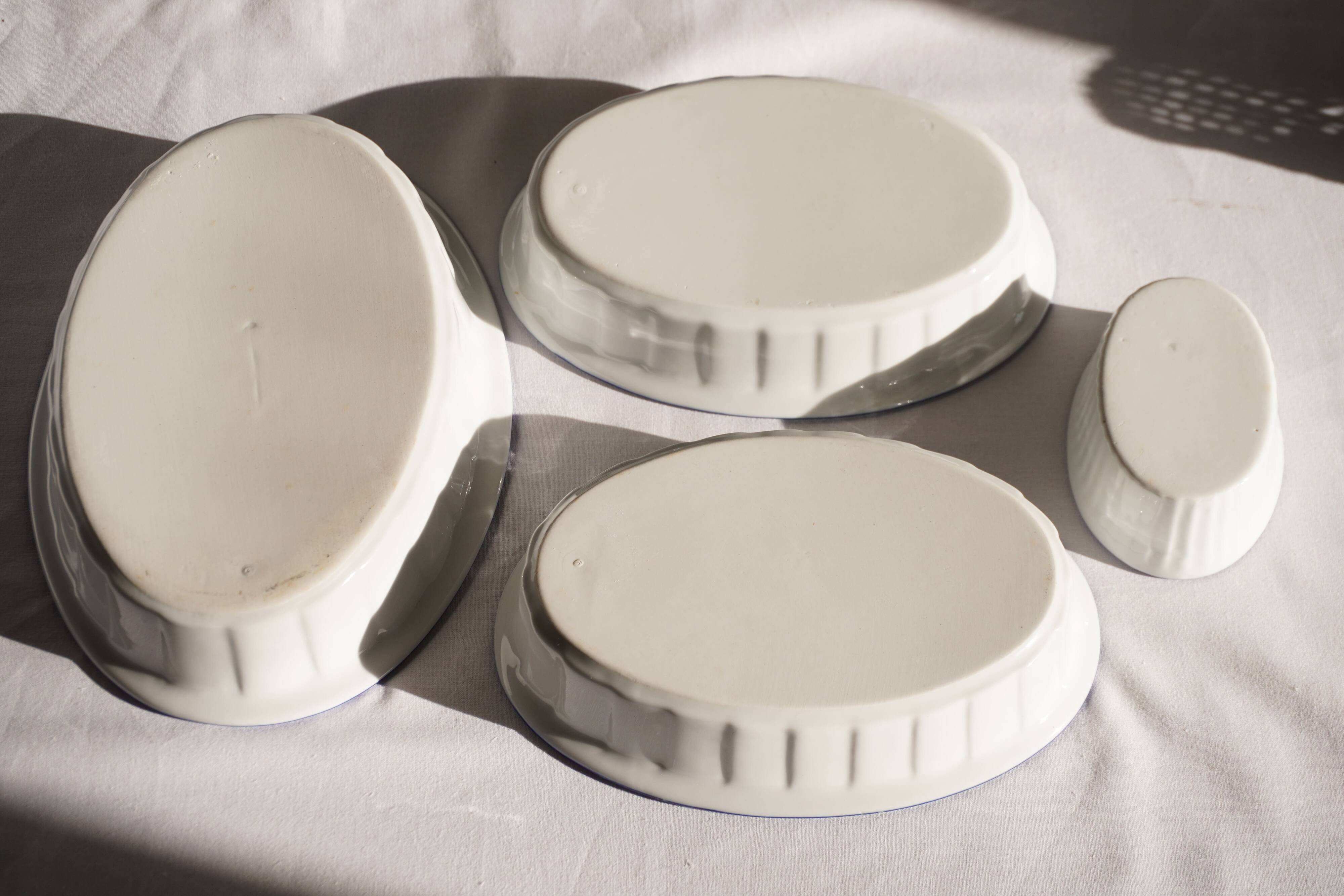 Set of 4 white porcelain dishes with blue decorations and wicker stands