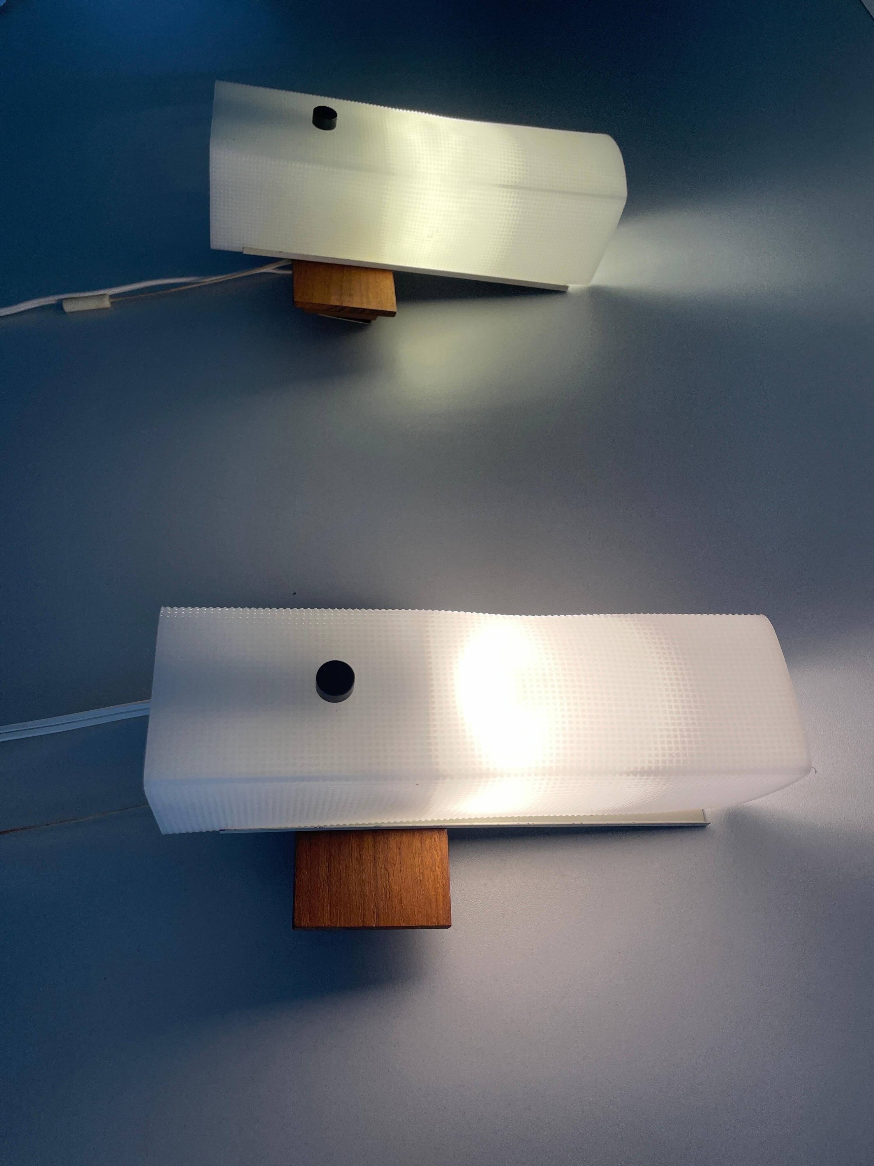 Mid-century wall lights in white plexiglass with a wooden base, 1960s, Germany.