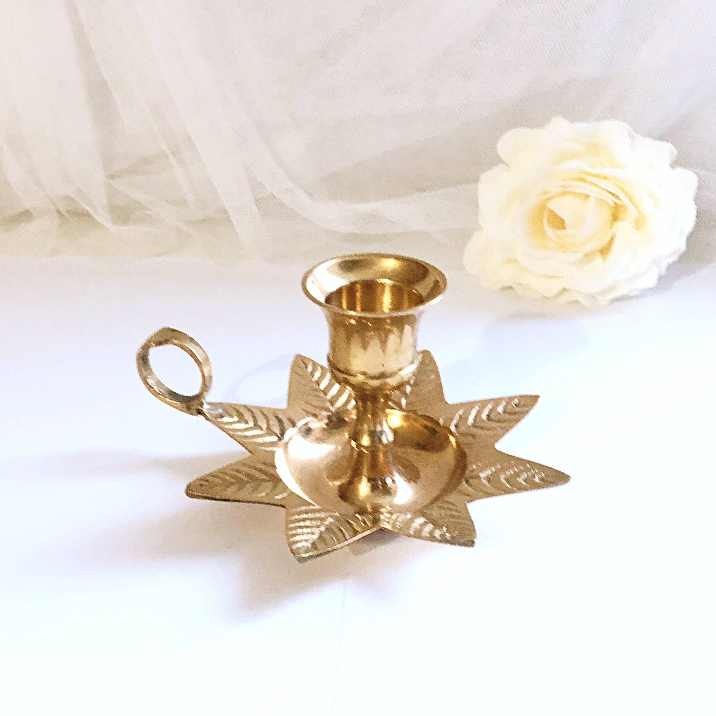 Golden brass hand candle holder decorated with leaves
