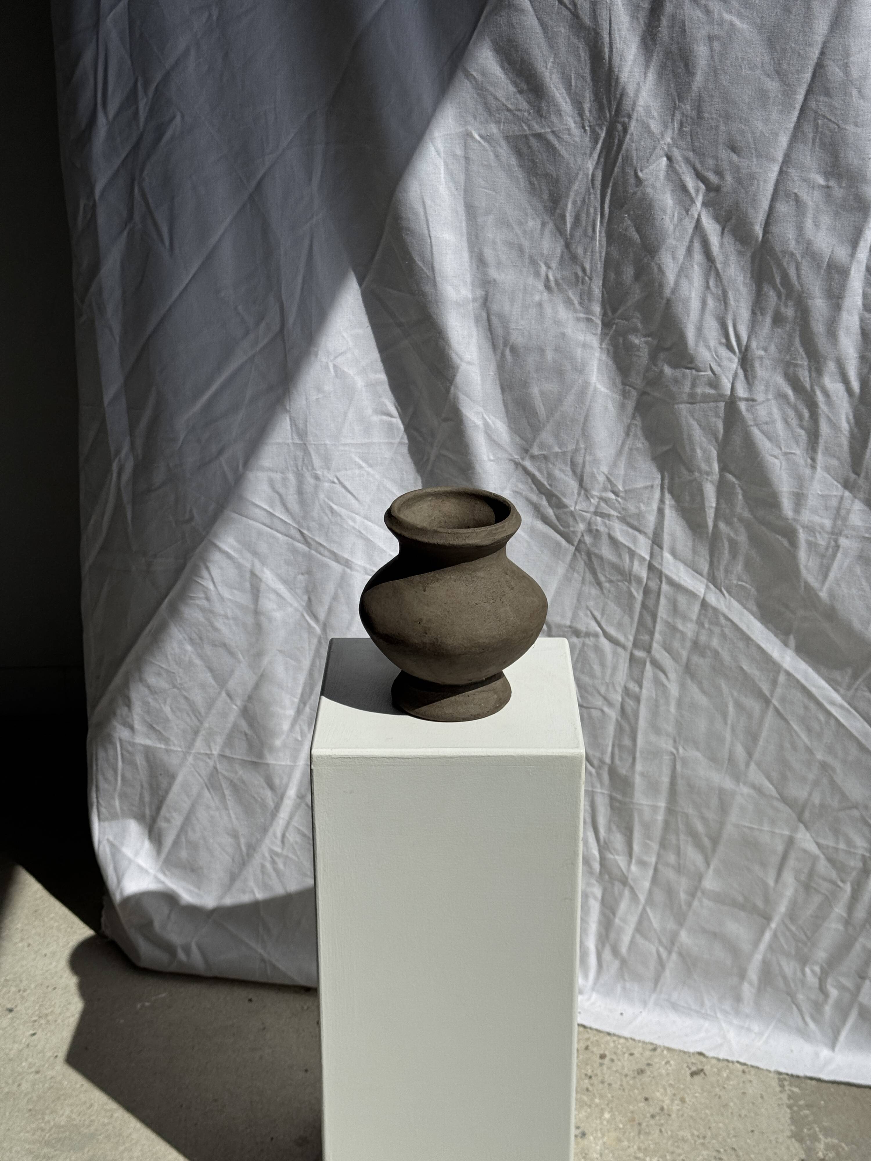 Small brutalist handcrafted terracotta vase with a pedestal, Indonesian, H19 D17.