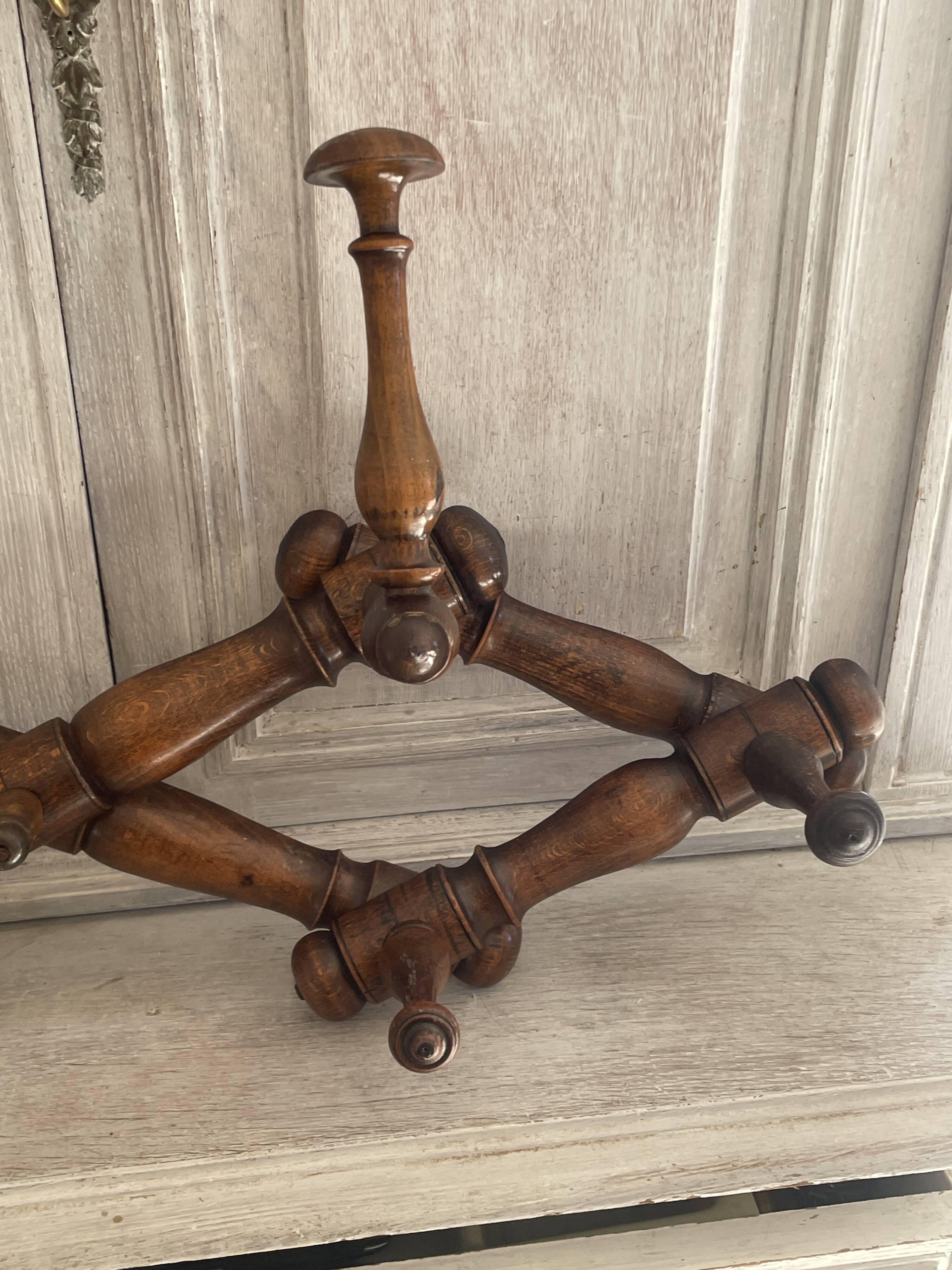 Wall-mounted accordion coat rack made of turned wood