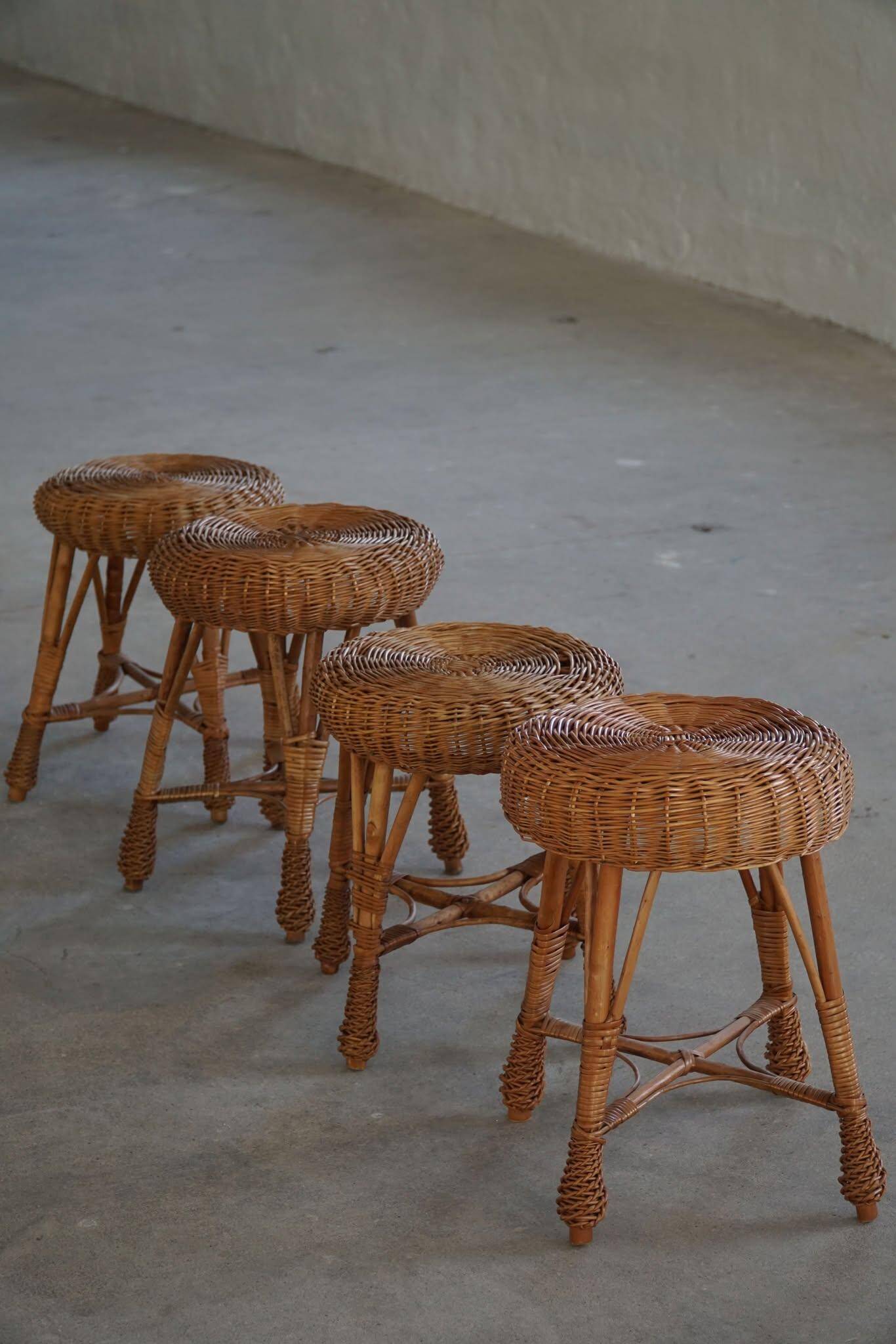 A set of 4 vintage Scandinavian rattan stools, in the style of Tony Paul, from the 1960s.