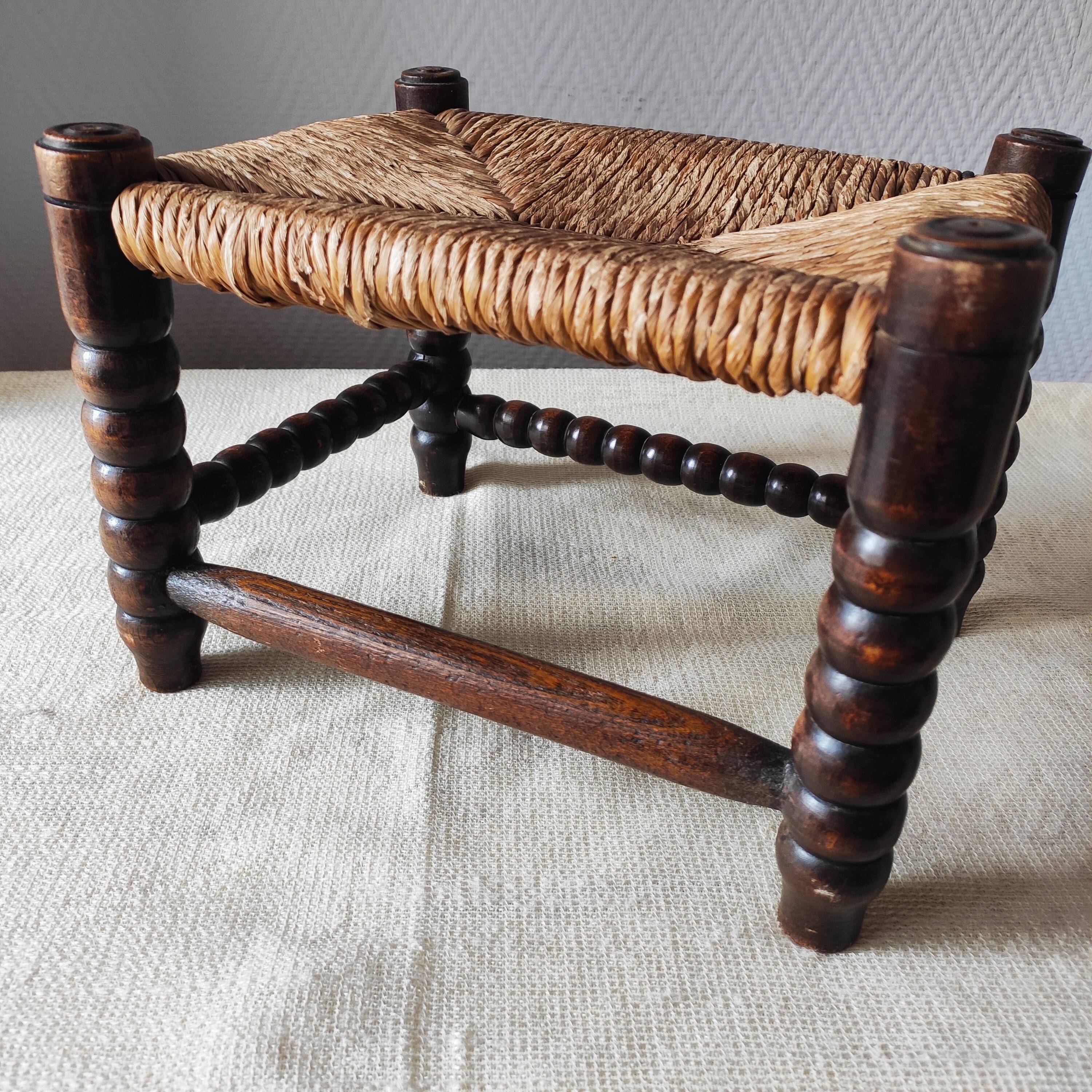 Antique wooden turned spool footrest with straw.