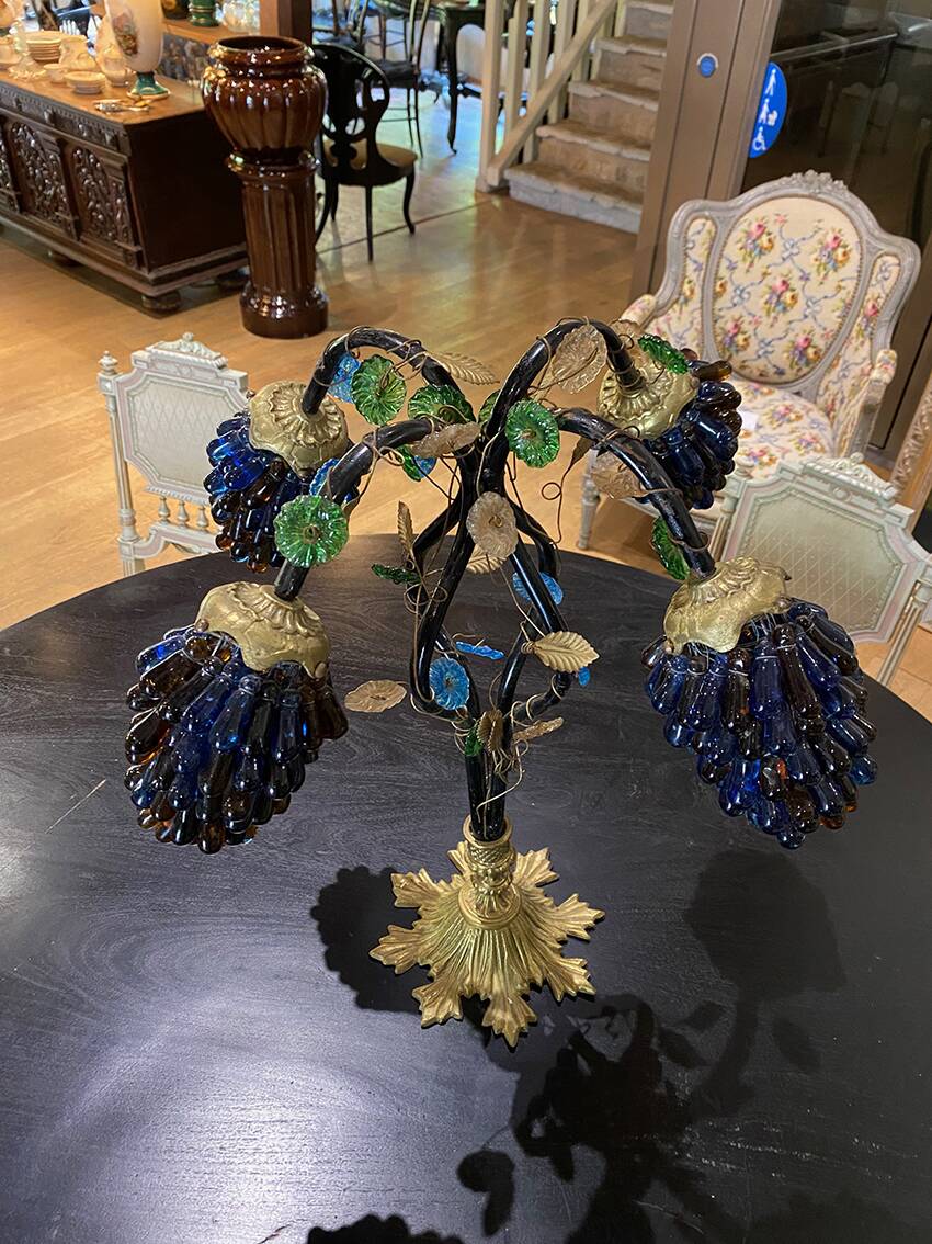 Table lamp with four light arms and globes shaped like bunches of grapes.