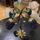 Table lamp with four light arms and globes shaped like bunches of grapes.