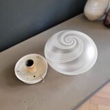 Frosted glass globe ceiling light with spiral patterns.